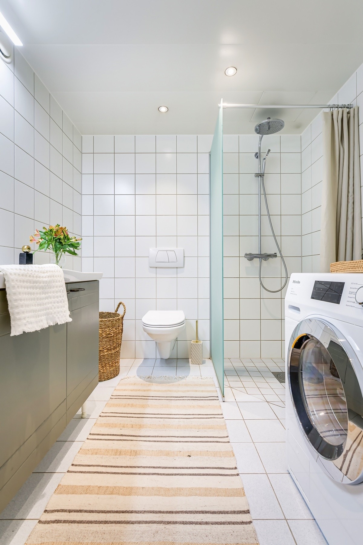 Badet har vegghengt toalett, samt dusjhjørne med vegghengte glassdører. Galleribilde