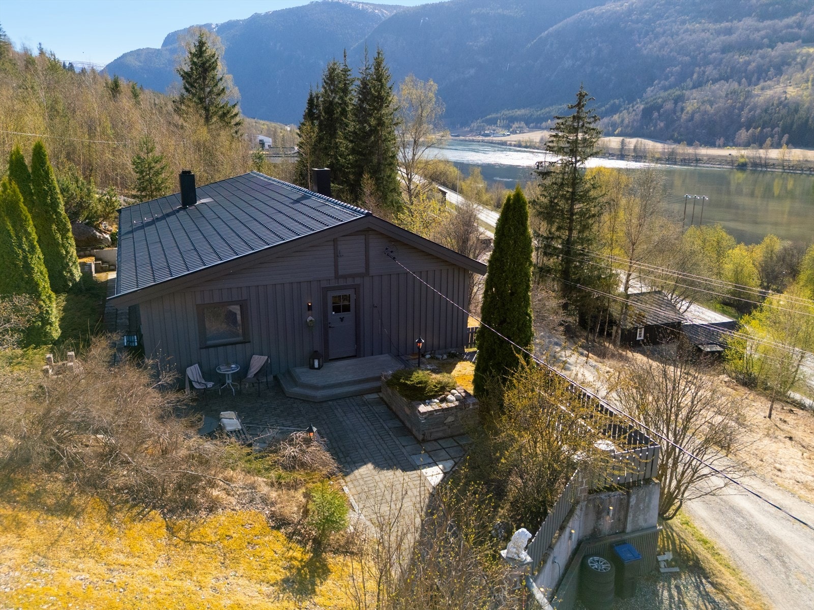 Uteområdet er opparbeidet m/grøntarealer, bed, samt noen busker og trær. Ned mot vei er det gjerde og mur. Galleribilde