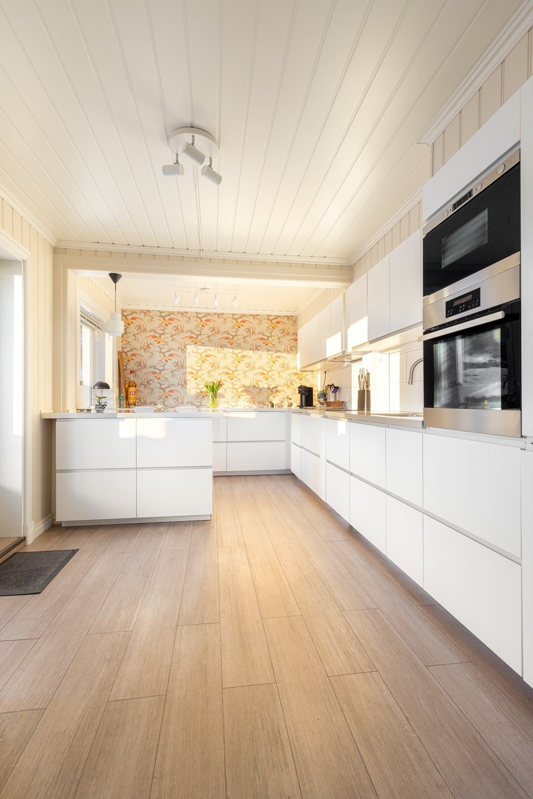 Det er gode arbeidsflater på laminerte benkeplater, hvor det er flis på vegg i sprutsoner ved koketopp og oppvaskkum. Alle hvitevarer integrert, som oppvaskmaskin, koketopp og kjøl/fryseskap, samt stekeovn og mikro plassert i praktisk arbeidshøyde i høyde Galleribilde