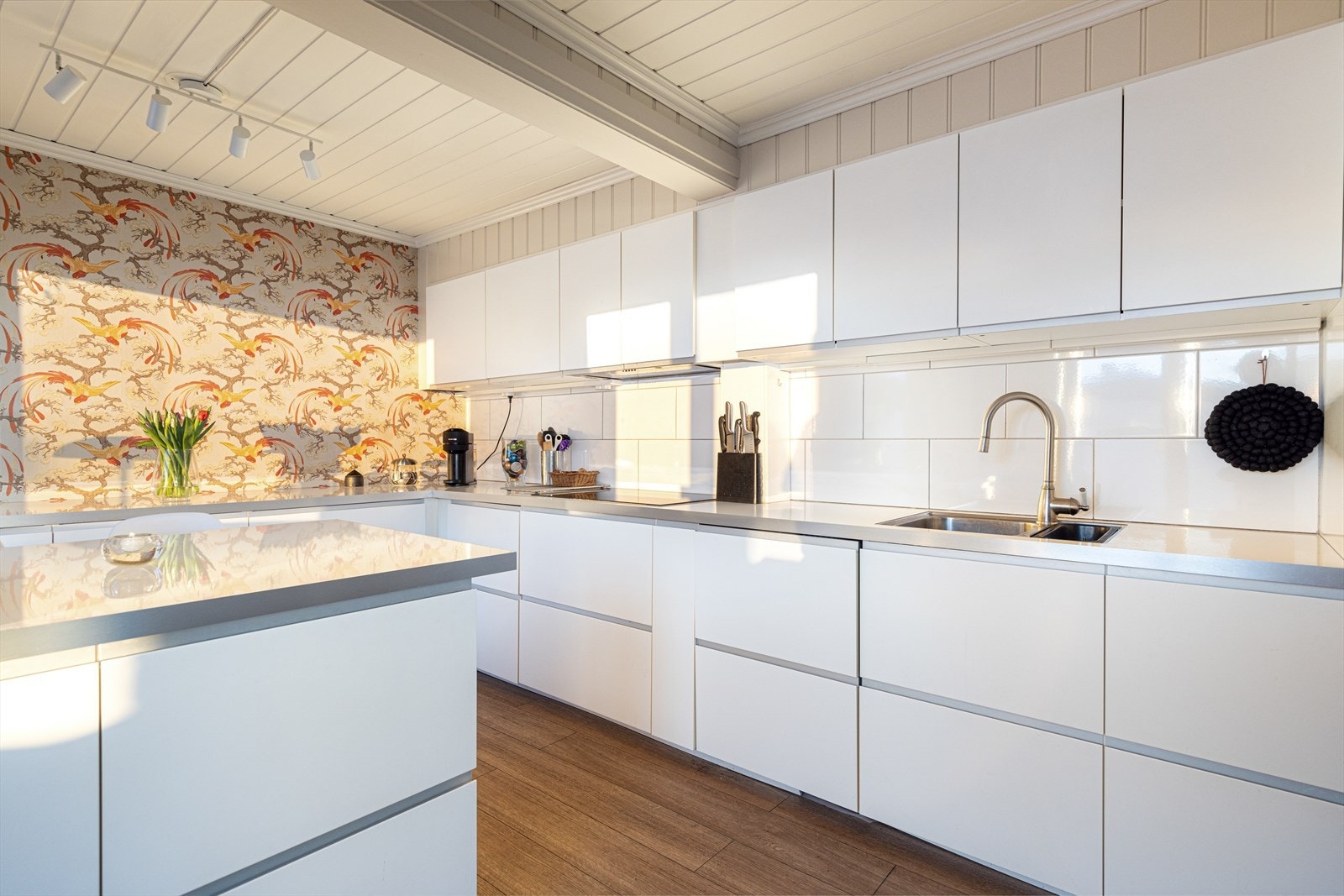 Inntil stuen ligger kjøkkenet som er på 15 m2. Her er plassen godt utnyttet, med tidløs innredning fra IKEA oppført i 2014. Fra kjøkkenet er det doble dører ut mot de sjenerøse terrasseområdene, med flere soner for møblering. Galleribilde