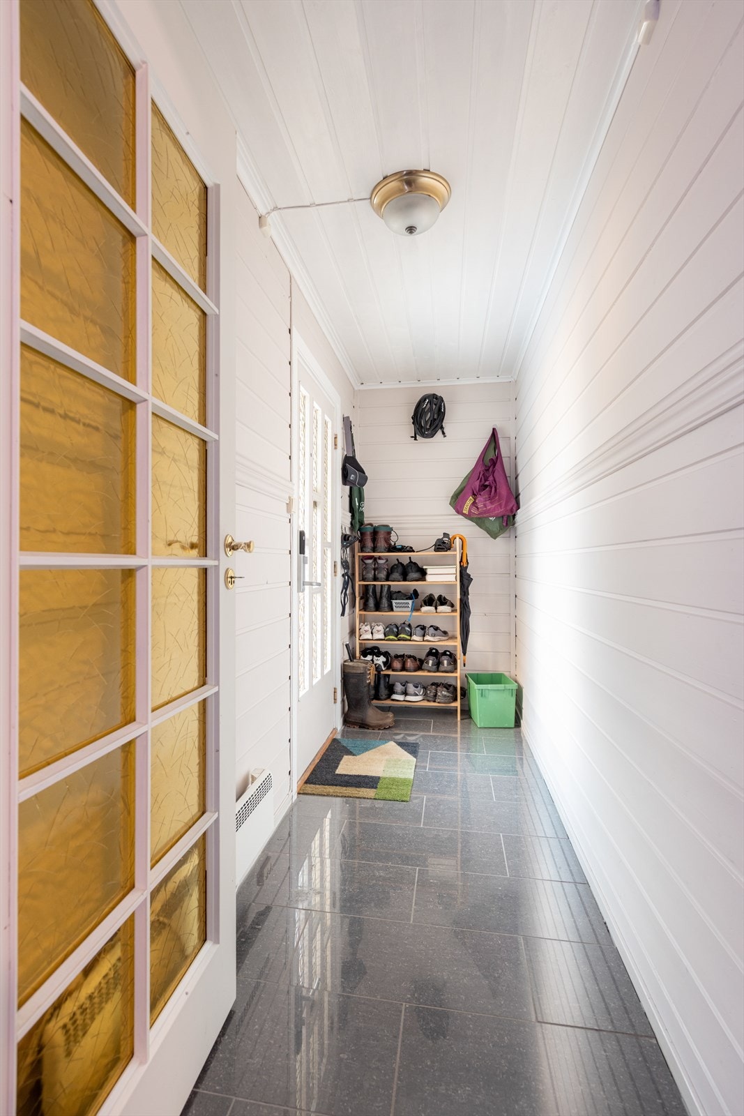 Med adkomst fra det hyggelig inngangspartiet kommer man inn i boligens entrè som er på 4 m2 og har flis på gulv, malt panel på vegger og i tak. Galleribilde