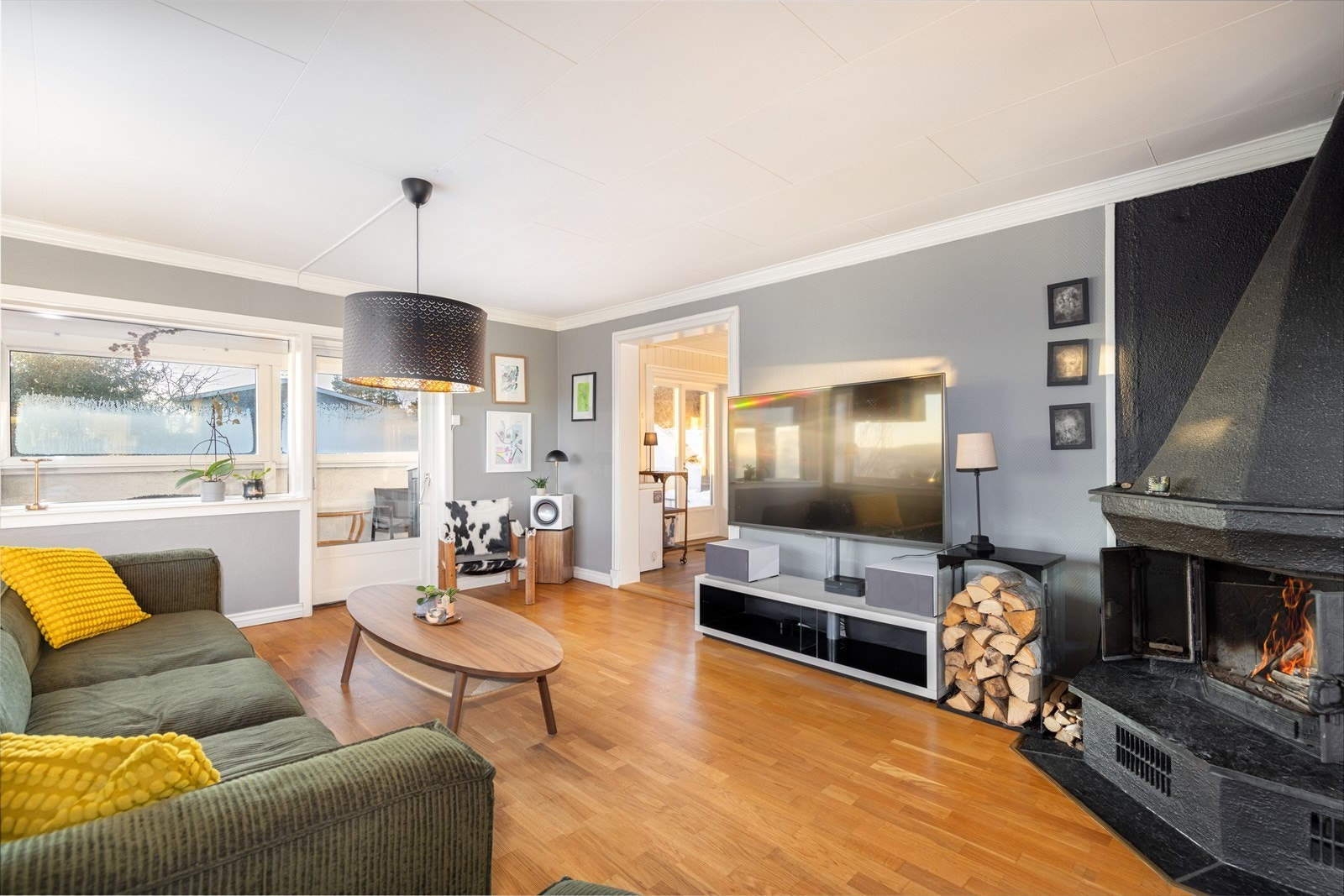 I dagligstuen er det en koselig peis med pyntehyller, og det er utgang til en lun og fin uteplass med takoverbygg og glassvinduer som tar inn den flotte utsikten mot øst. Galleribilde