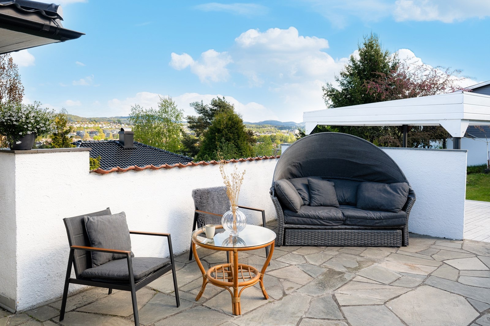 Med adkomst både fra stuen og kjøkkenet er det en romslig terrasse på ca. 40 m2 med skiferheller, hvor den ene delen har en lun, innebygget plass med vindusglass som tar inn den flotte utsikten. Galleribilde