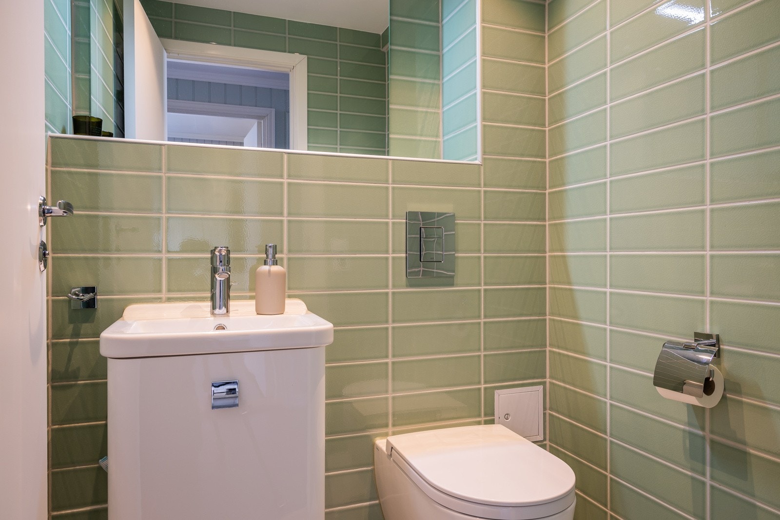 Boligen har et moderne toalettrom i 1.etg. med lyse fliser på både vegger og gulv, samt en malt himling som gir et rent og stilrent uttrykk. Galleribilde