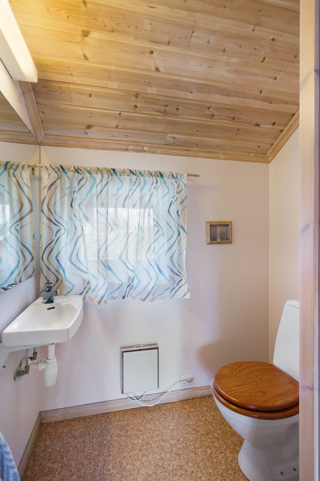 Toalettrommet har gulvbelegg og malte plater på veggene, og er innredet med gulvmontert toalett og servant. Galleribilde