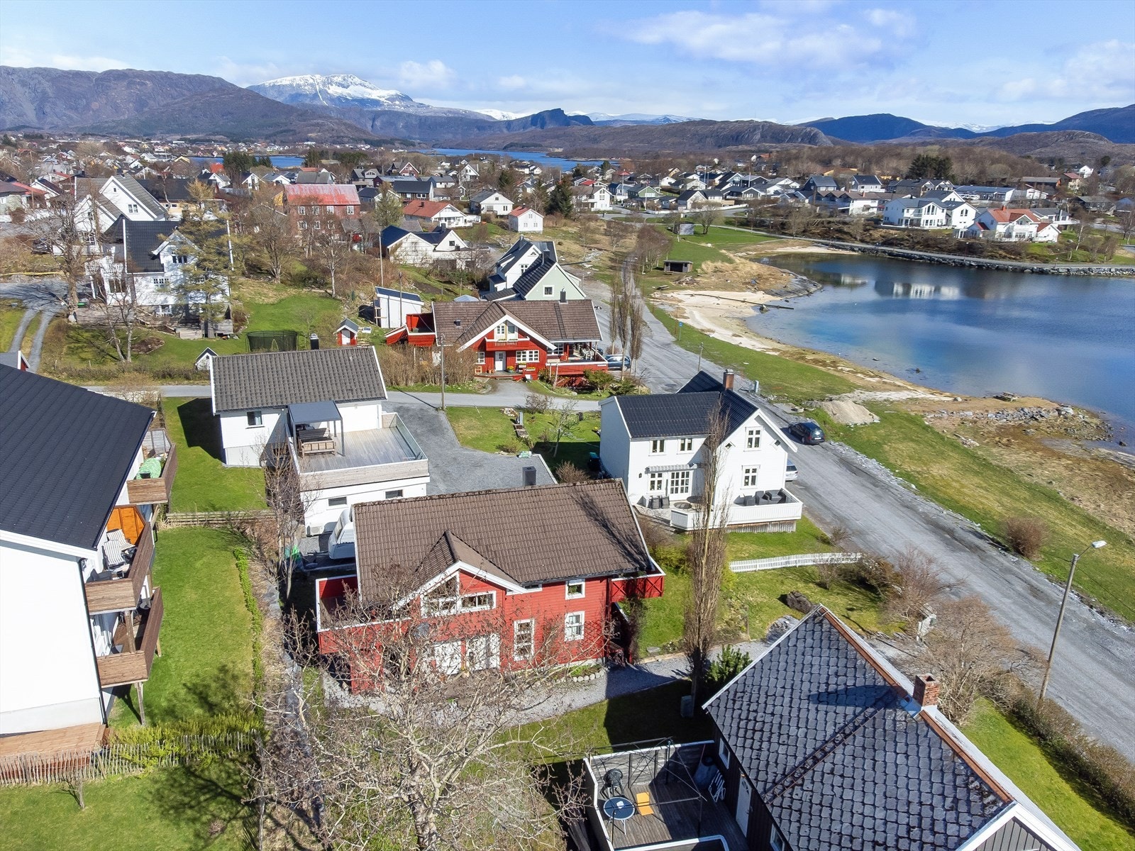 Gruset innkjørsel med parkeringsplass, og gruset gangvei som fører opp til boligens inngangsparti. Galleribilde