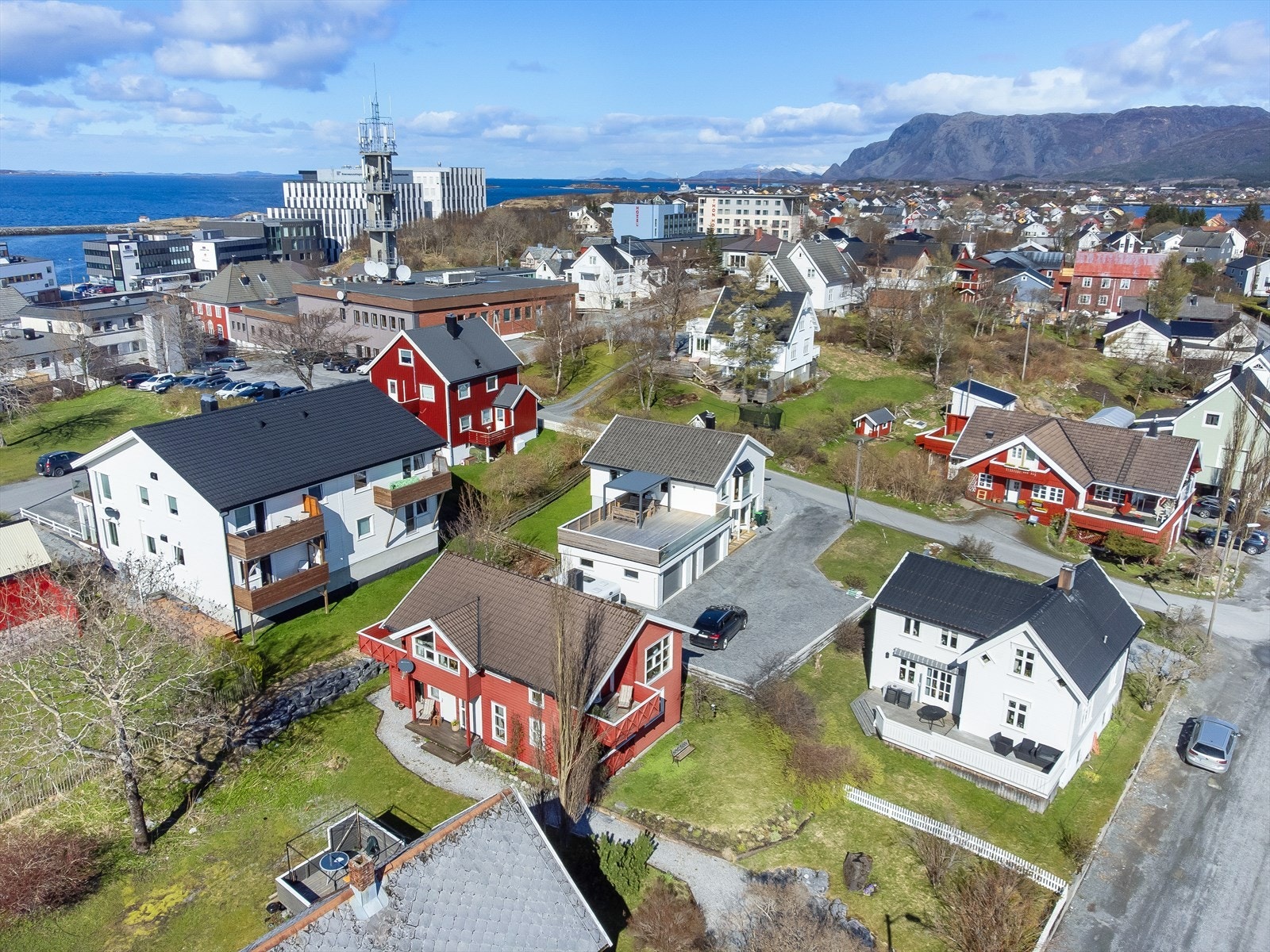Eiendommen er delvis inngjerdet med et hvitmalt tregjerde mot veien i øst og videre langs deler av grensen mot naboen i nord, noe som gir en tydelig avgrensning og en privat atmosfære. Galleribilde