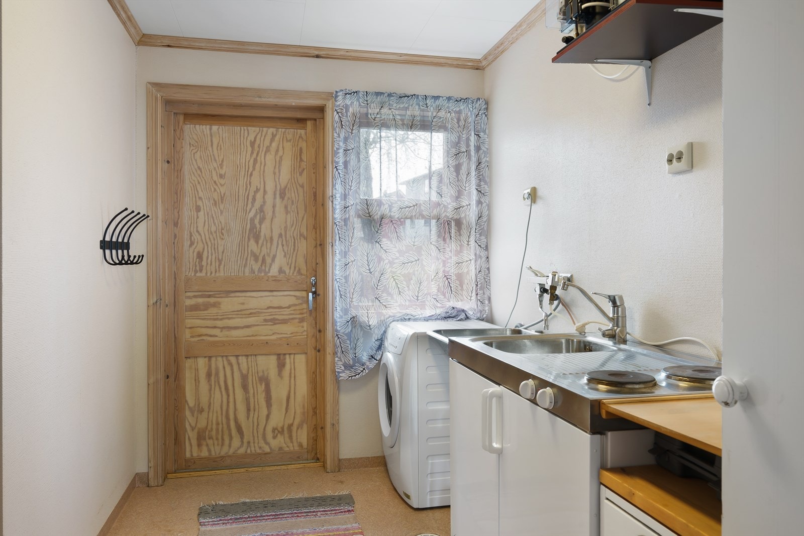 Innredet med benk med nedfelt utslagsvask, to kokeplater og kjøleskap, samt opplegg for vaskemaskin. Rommet ventileres med mekanisk avtrekk og tilluft ved dørterskel. Galleribilde