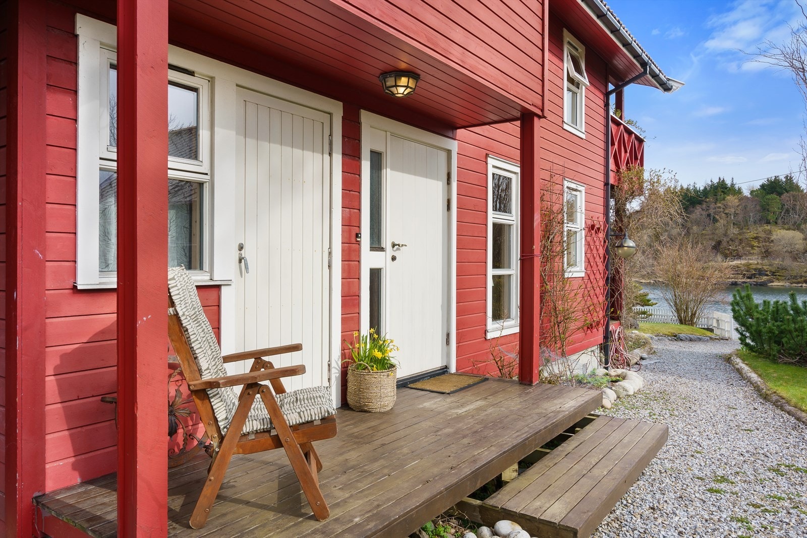 Inngangen vender mot sør og har en tretrapp og ytterdør med sidefelt av glass. Galleribilde