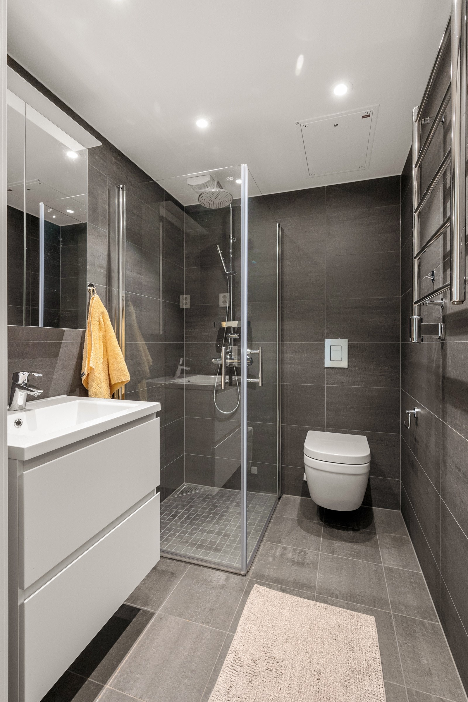 Det andre badet har adkomst fra entré. Utstyrt med veggmontert wc, servantskap med blandebatteri og dusjhjørne med dusjarmatur Galleribilde
