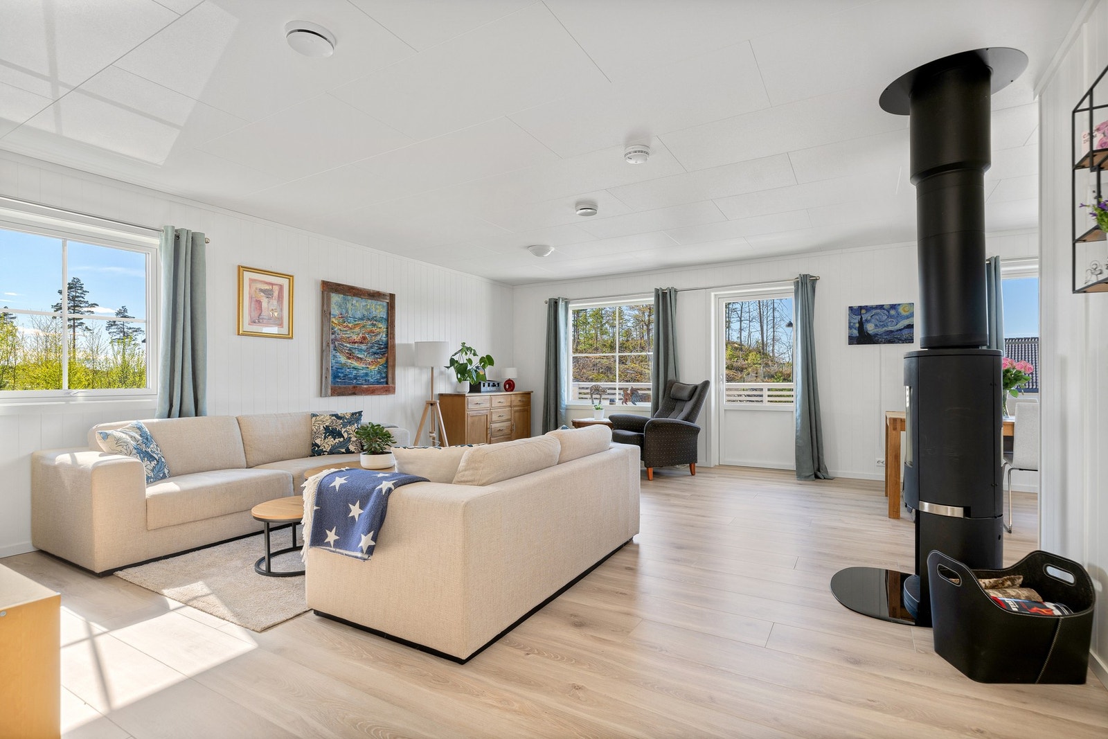 Stor og lys stue med god plass til flere sittegrupper Galleribilde