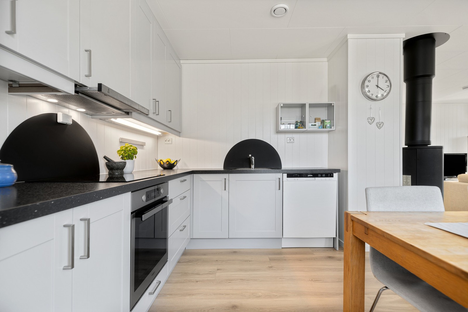 God skap- og benkeplass på kjøkkenet. Praktiske "backsplash"-skjermer bak platetopp og vask Galleribilde