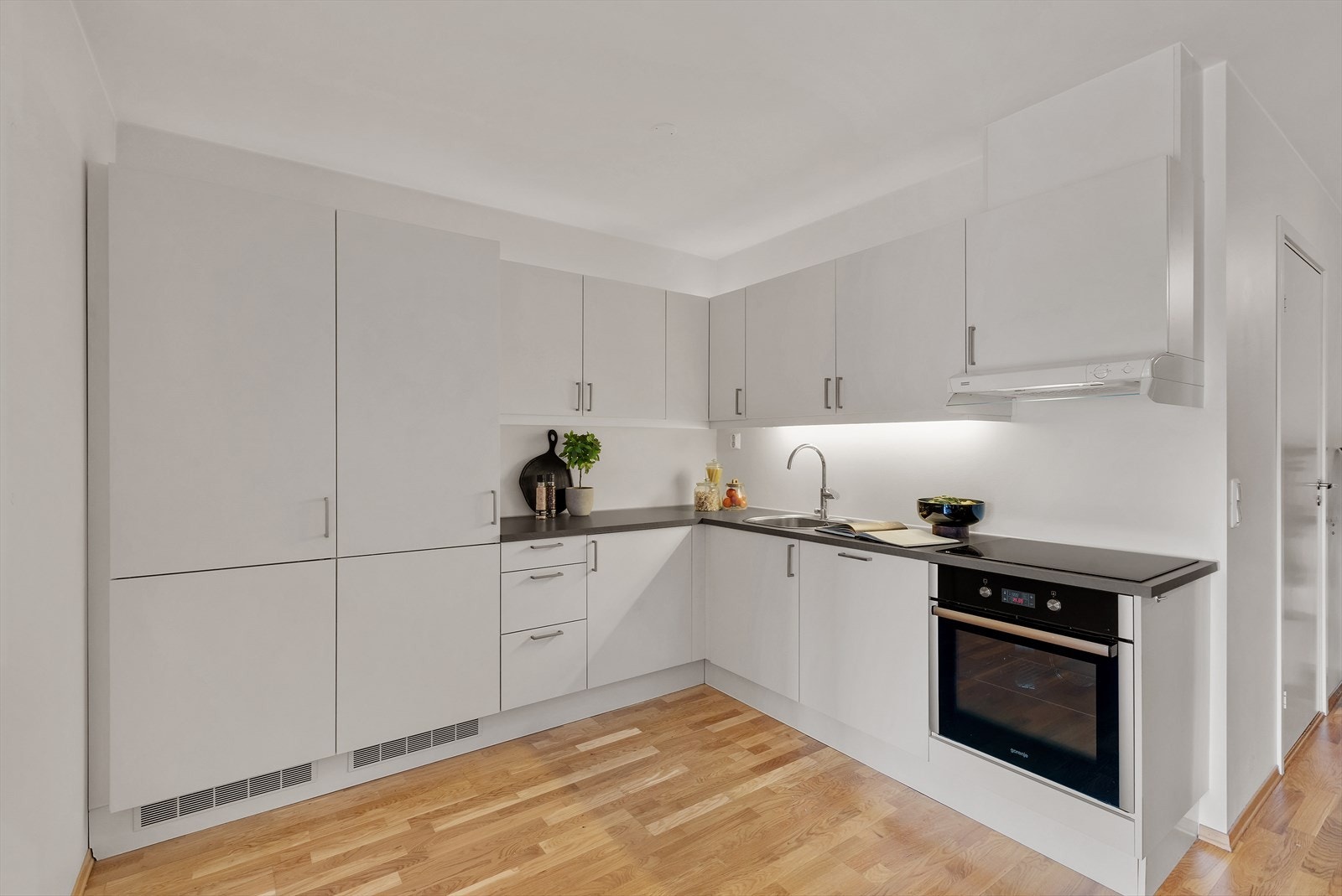 Flott og moderne HTH-kjøkken med integrert frys, kjøleskap og komfyr. Galleribilde