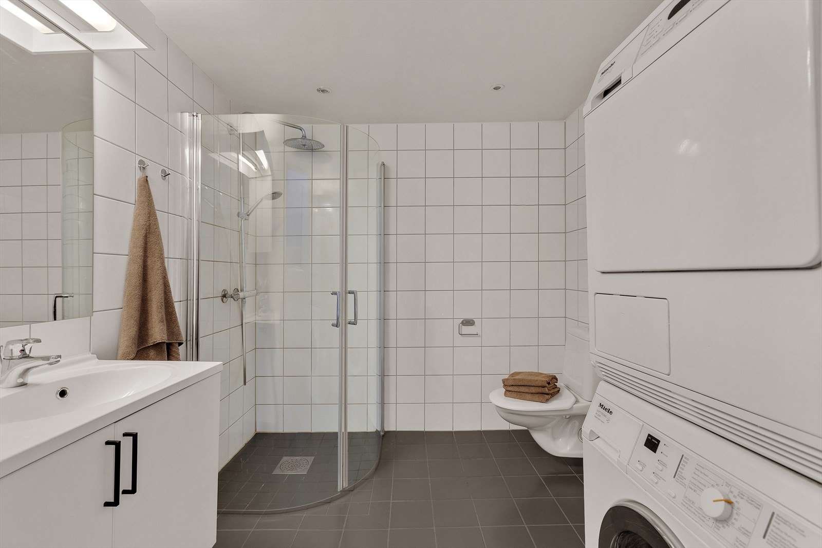 Lyst og pent fliselagt bad, med varmekabler i gulv. Galleribilde