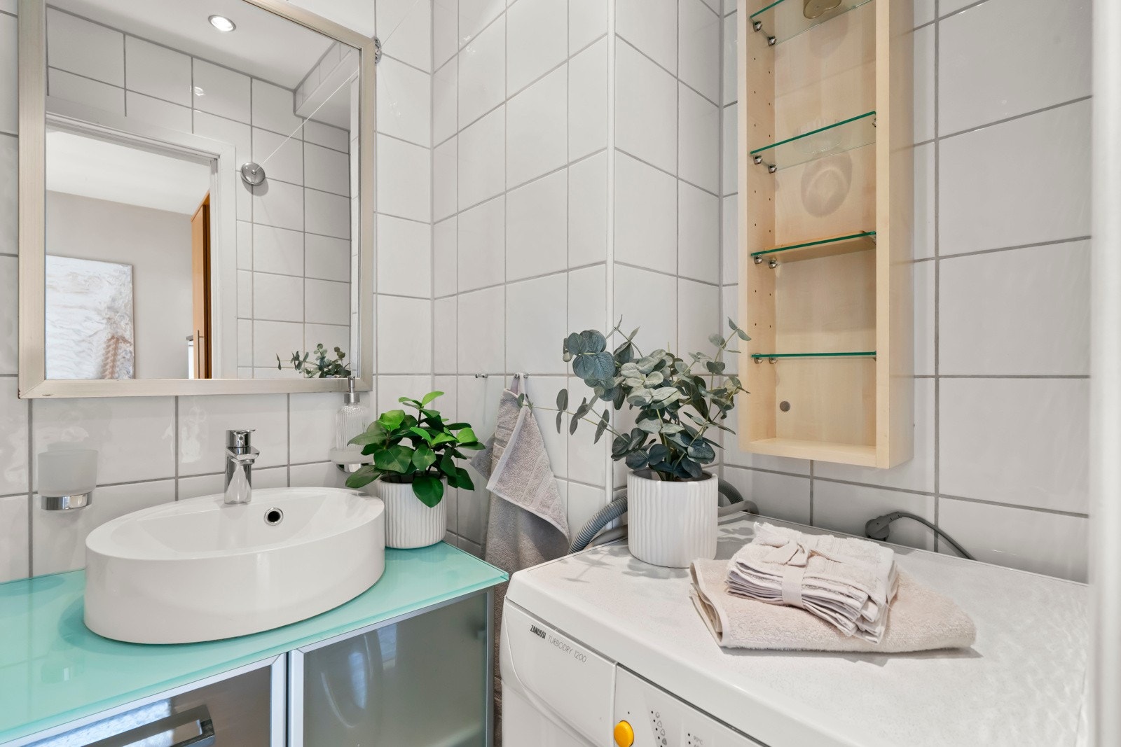 Badet har en lys og tidløs utførelse, med praktisk planløsning som utnytter plassen godt Galleribilde
