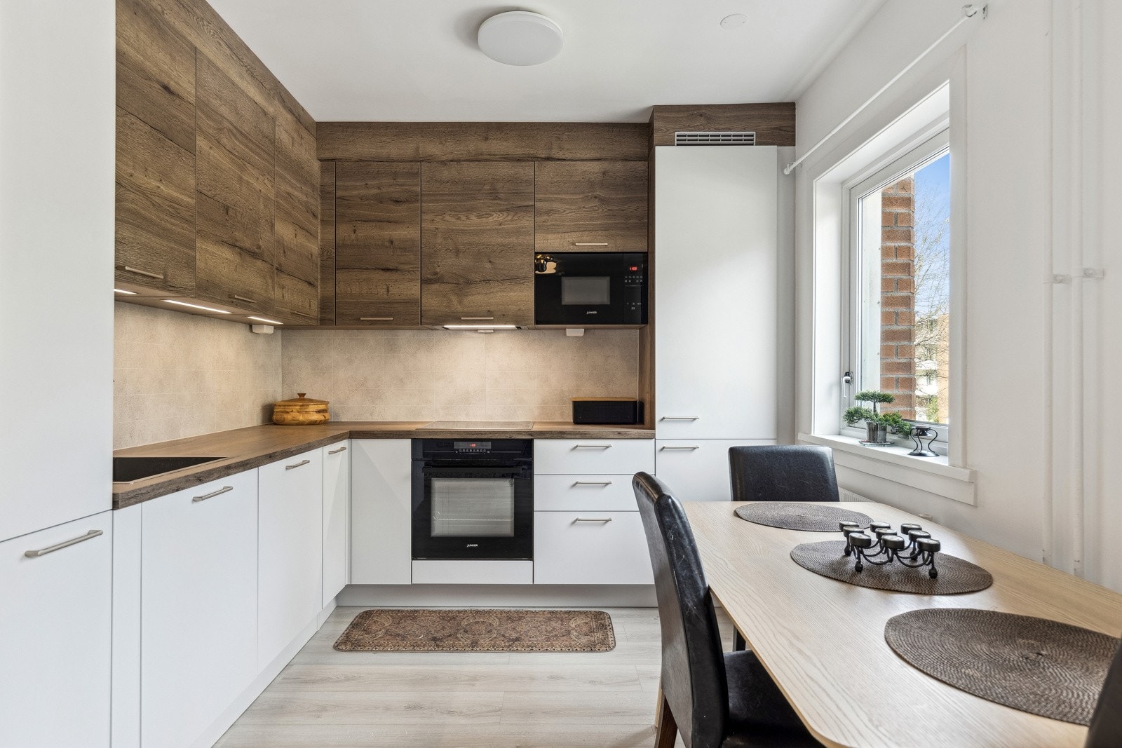 Integrerte hvitevarer inkludert stekeovn, platetopp, mikrobølgeovn, oppvaskmaskin og kjøle-/fryseskap gir et helhetlig og moderne uttrykk Galleribilde