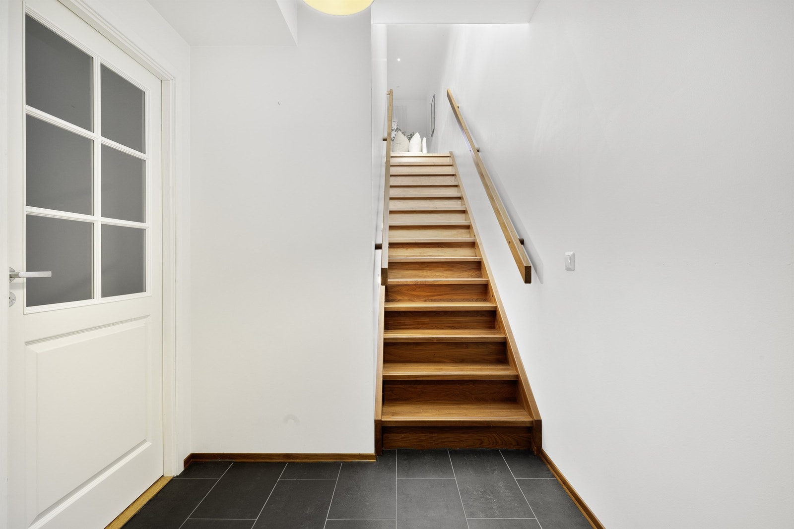 Praktisk inngangsparti med plass til oppbevaring av ytterklær. Oppgang til boligens 2. etasje. Galleribilde