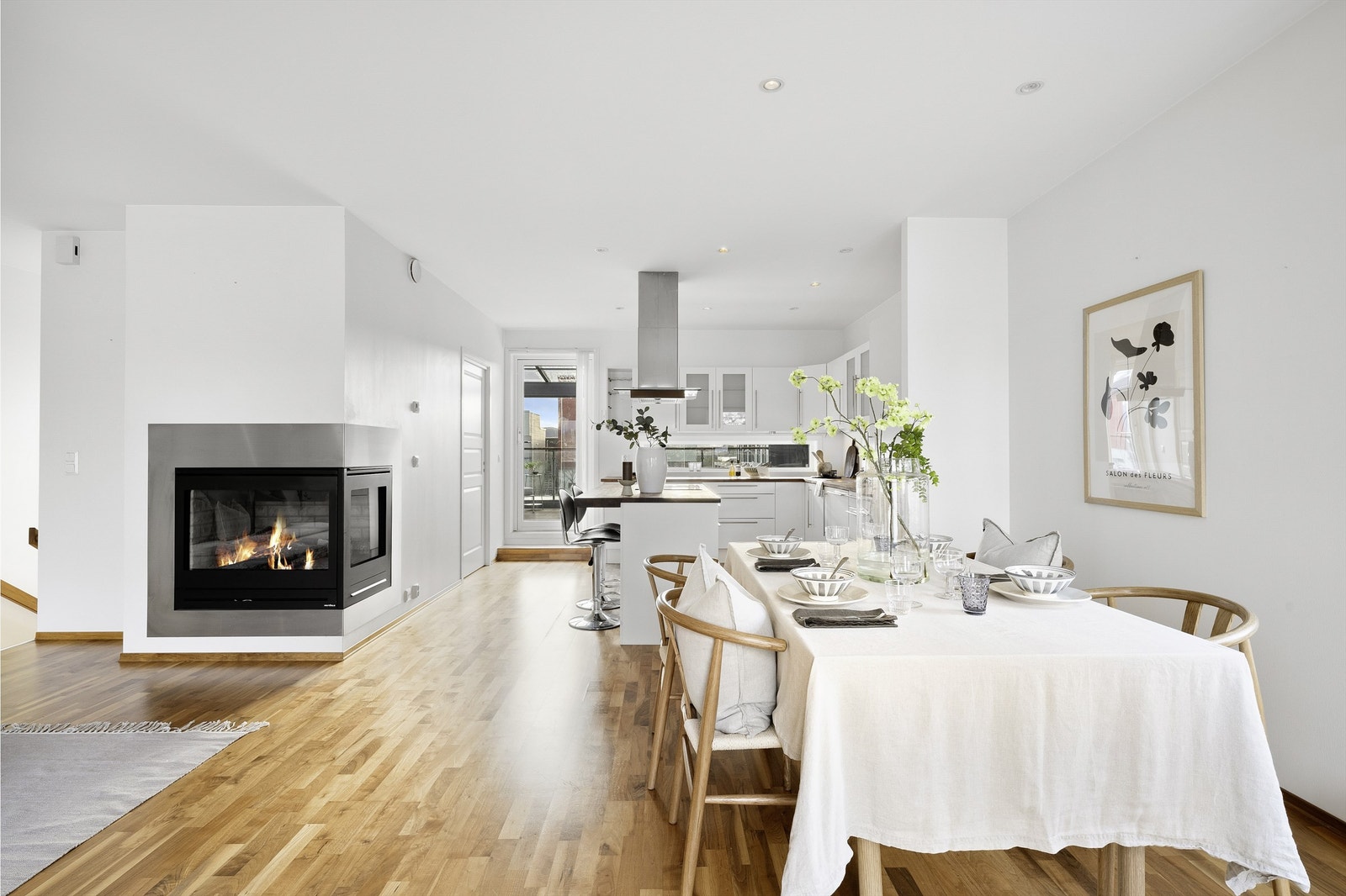 Enkelt, stilrent kjøkken fra Norema med fronter i hvit overflate som gir en moderne stil og et lyst og romslig preg, praktisk kjøkkenøy og lekre detaljer. Galleribilde