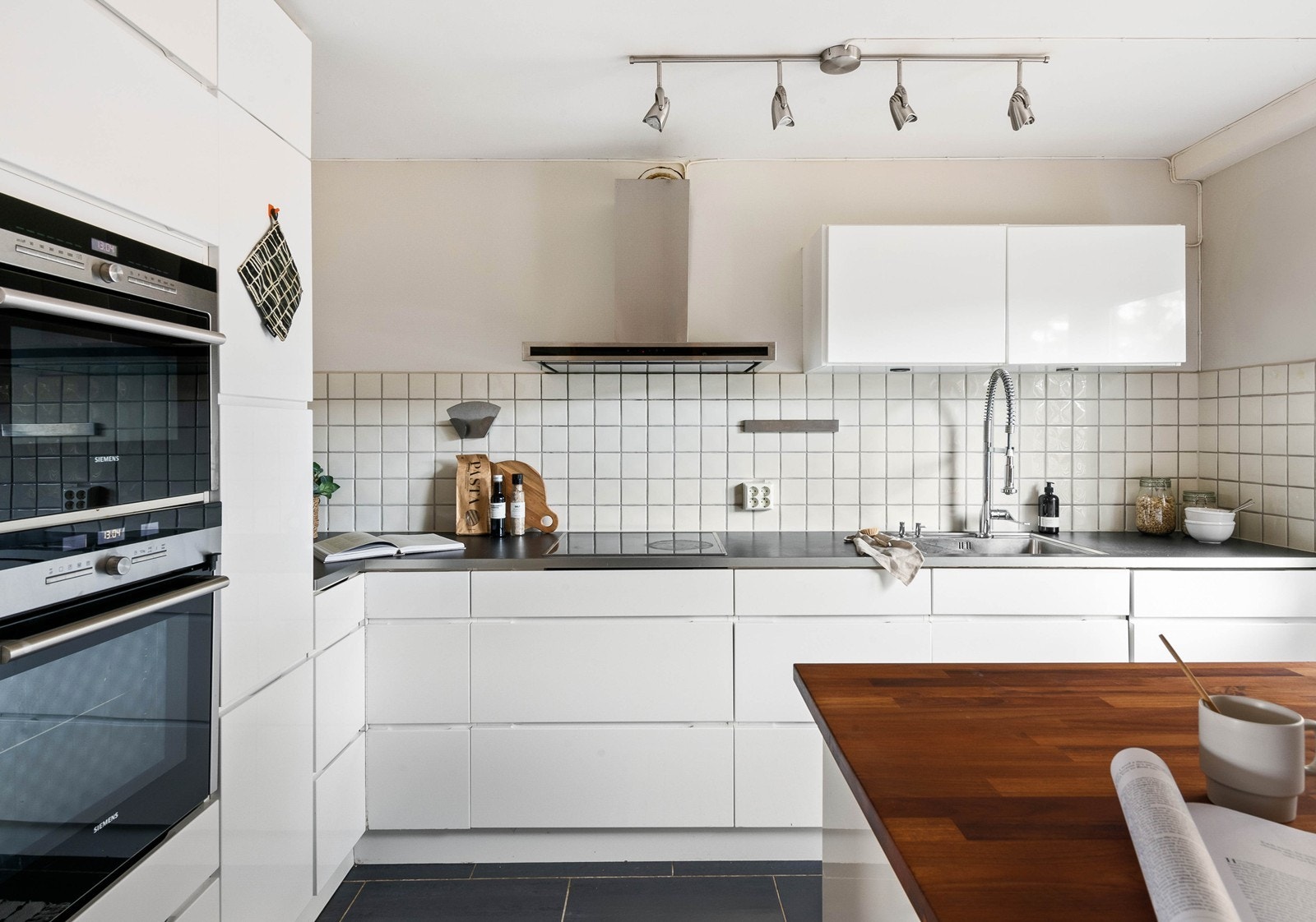 Kjøkkeninnredning bestående av laminat og heltre benkeplate, kjøleskap, oppvaskmaskin, platetopp, micro og stekeovn. Galleribilde