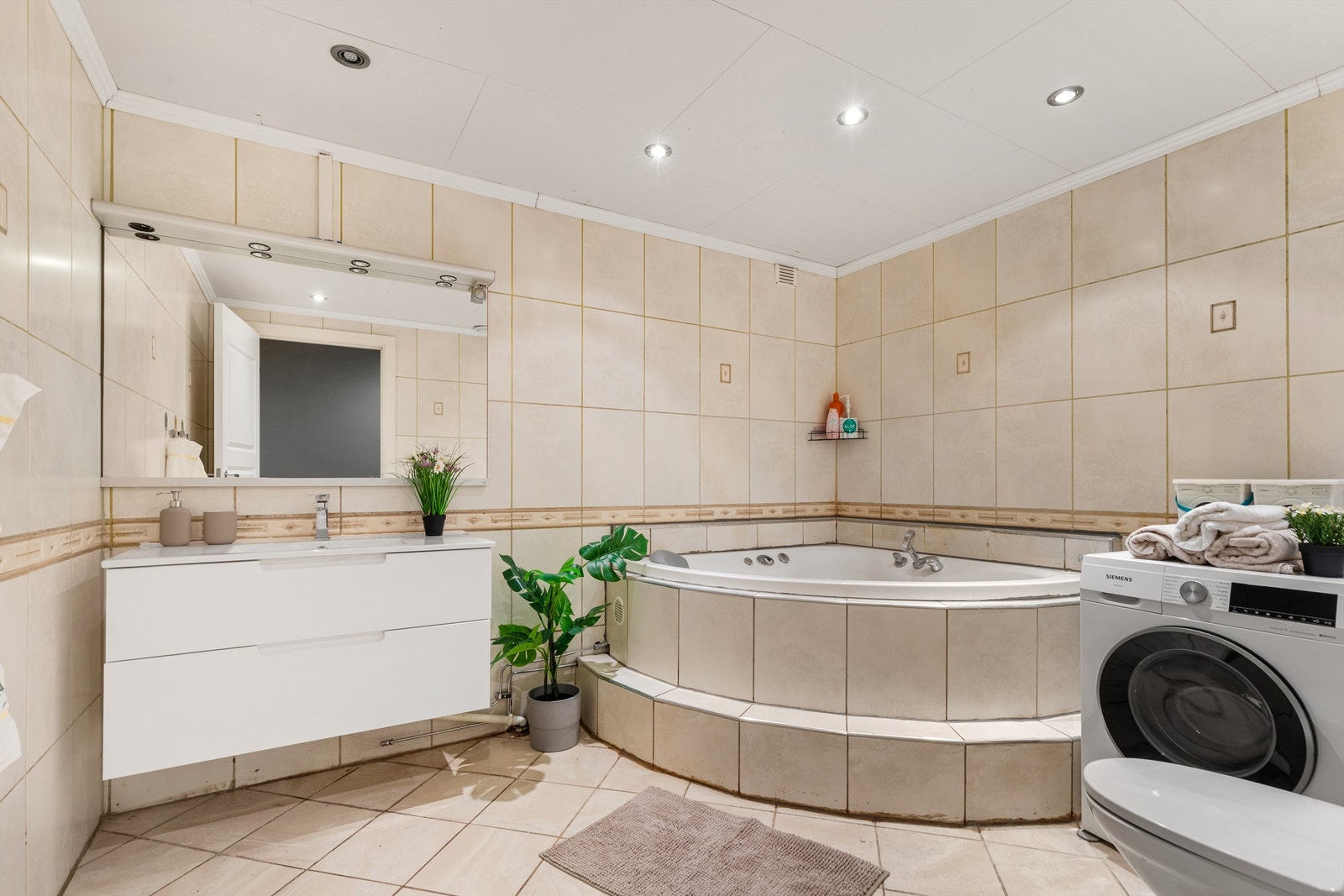 Baderommet er pent flislagt på gulv og vegger med varme i gulvet. Innredning består av servant nedfelt i innredningen, samt speil med overbelysning og stikkontakter. Det er opplegg for vaskemaskin. Galleribilde