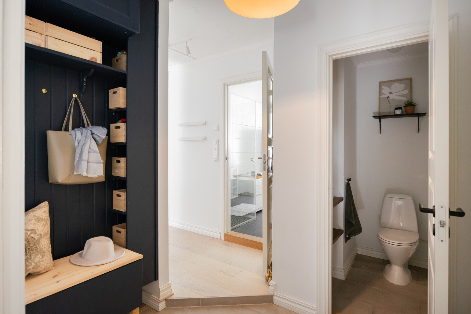 Romslig, flislagt inngangsparti med plassbygd oppbevaringsnisje og tilgang til toalett. Galleribilde