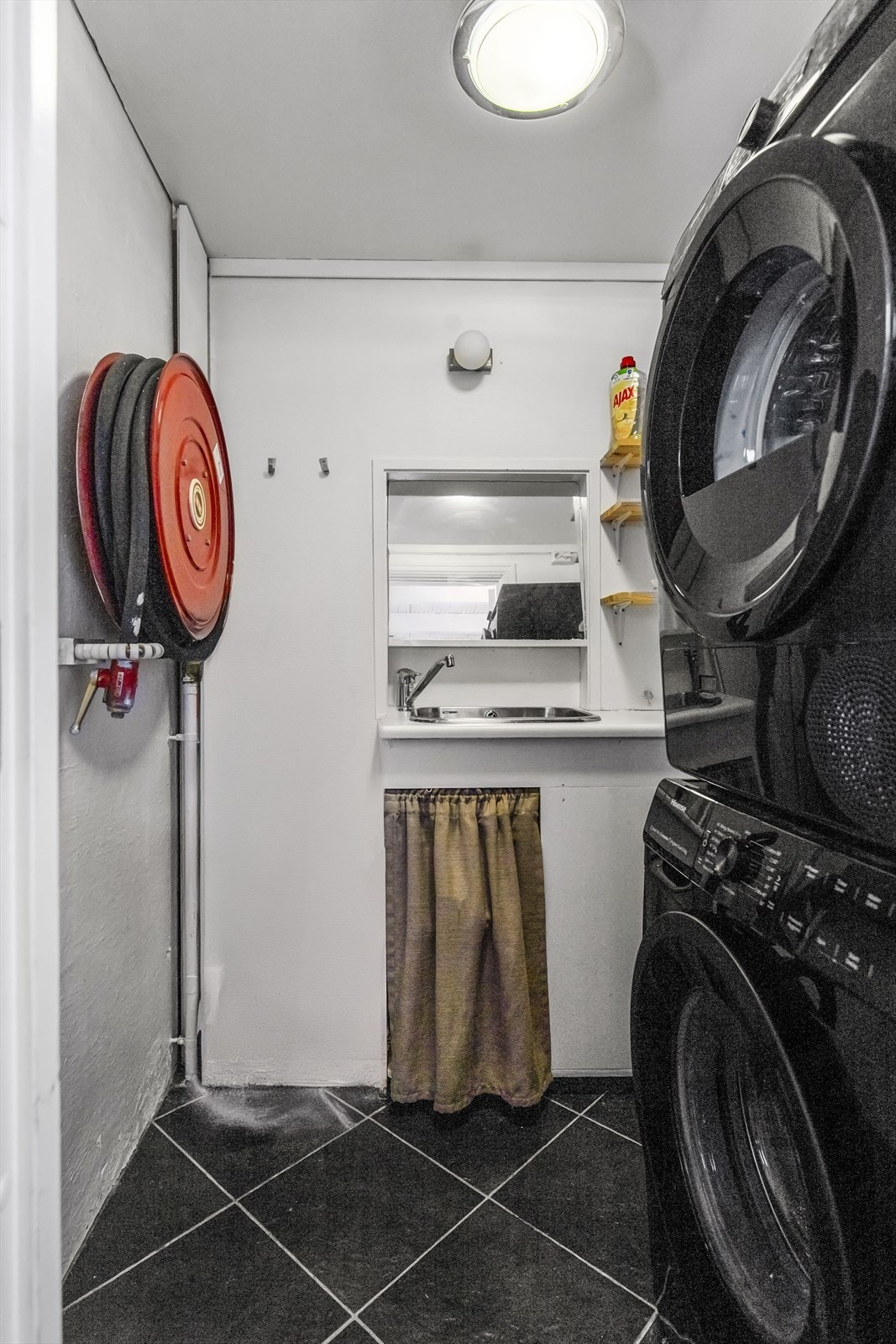 Fra gangen har du tilgang til vaskerom. Vaskerommet har fliser på gulv fra antatt 2004 og tapet og mur på vegger som er malt opp i nyere tid. Rommet inneholder opplegg for vaskemaskin, utslagsvask, benk og skap. Galleribilde