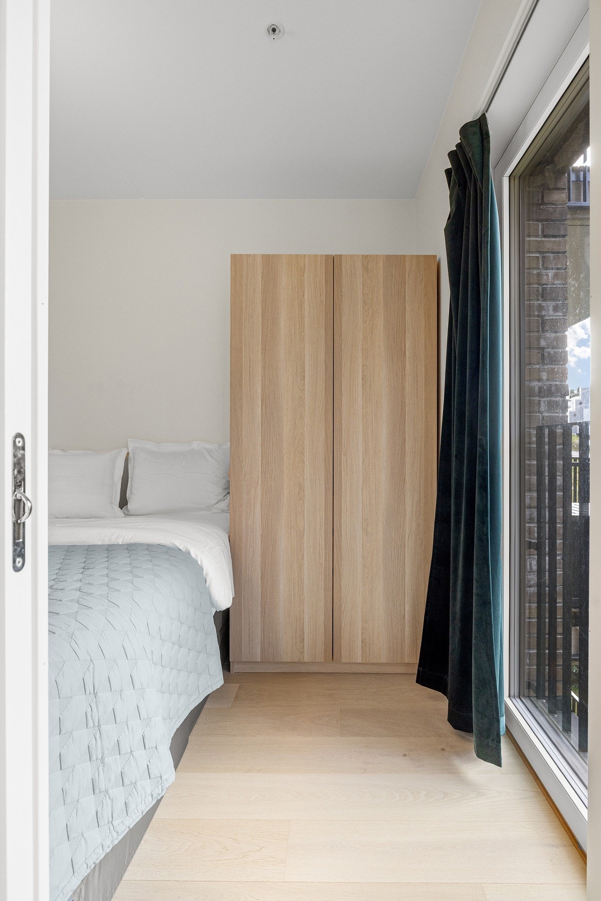 En fransk balkong åpner opp rommet og gir et trivelig utsyn mot grøntområde, noe som bidrar til en rolig og avslappende atmosfære. Galleribilde