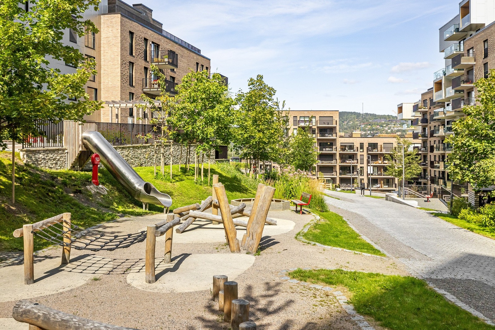 Store, grønne uteområder med inspirasjon fra Mærradalen gir byggene identitet og karakter. Galleribilde