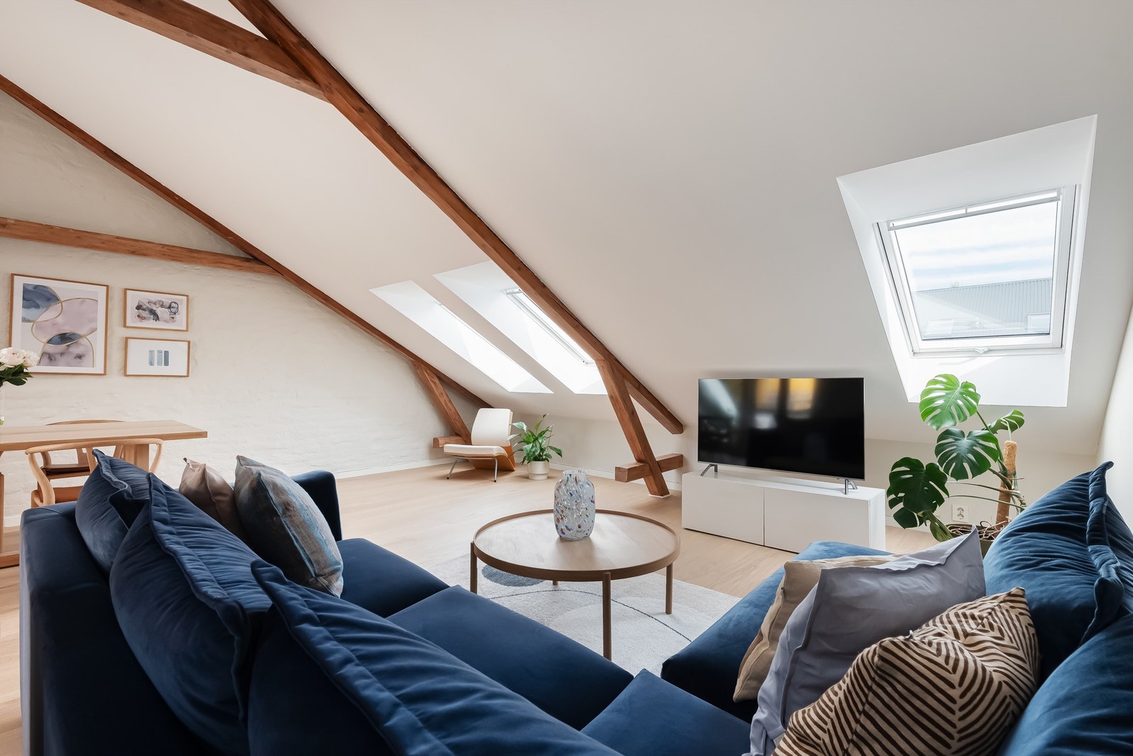 Store vindusflater som slipper inn rikelig med lys, kombinert med den generøse takhøyden skaper en lys og luftig atmosfære i stuen. Galleribilde