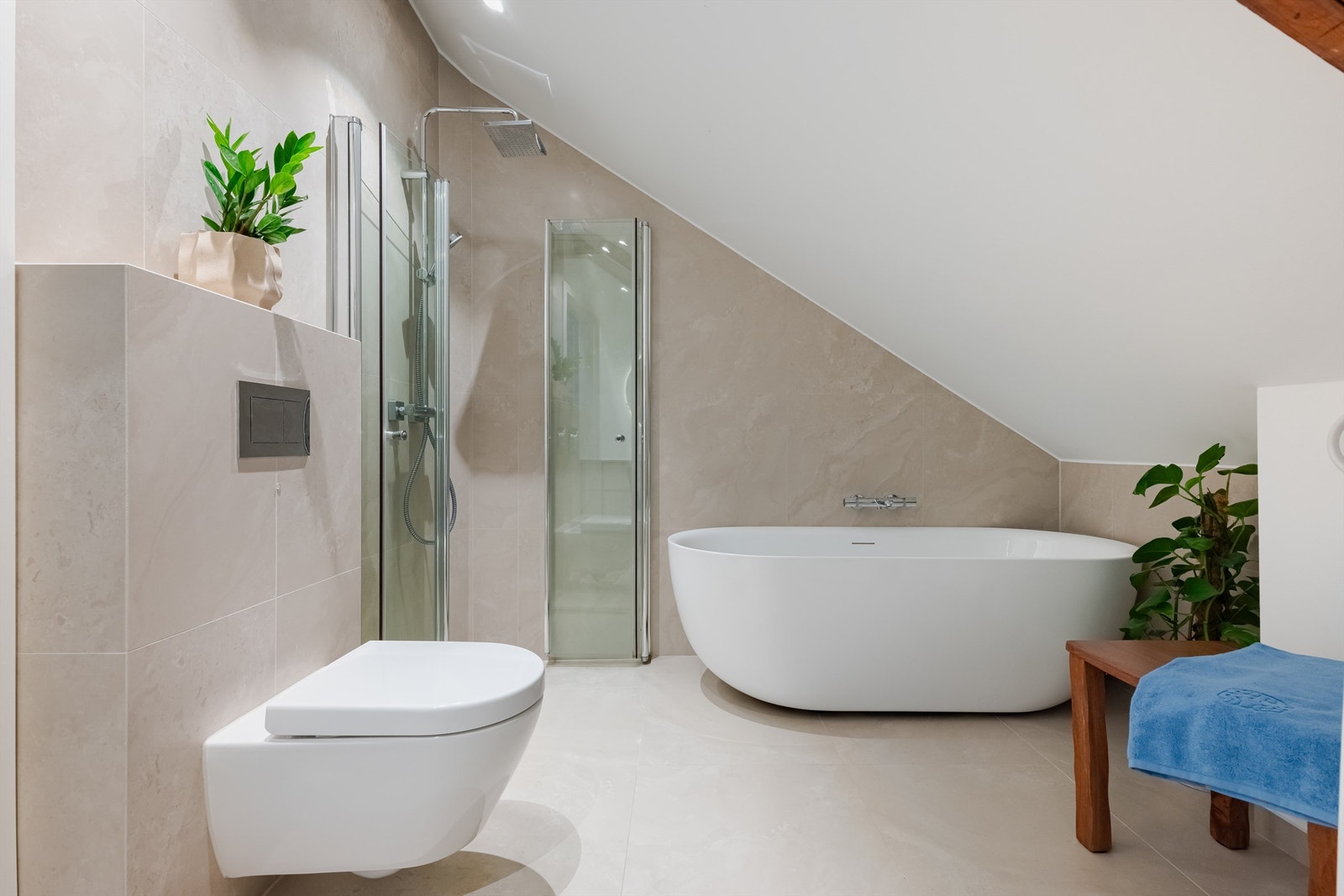 Videre har badet badekar og dusjhjørne med svingbare glassdører, samt vegghengt klosett. Galleribilde