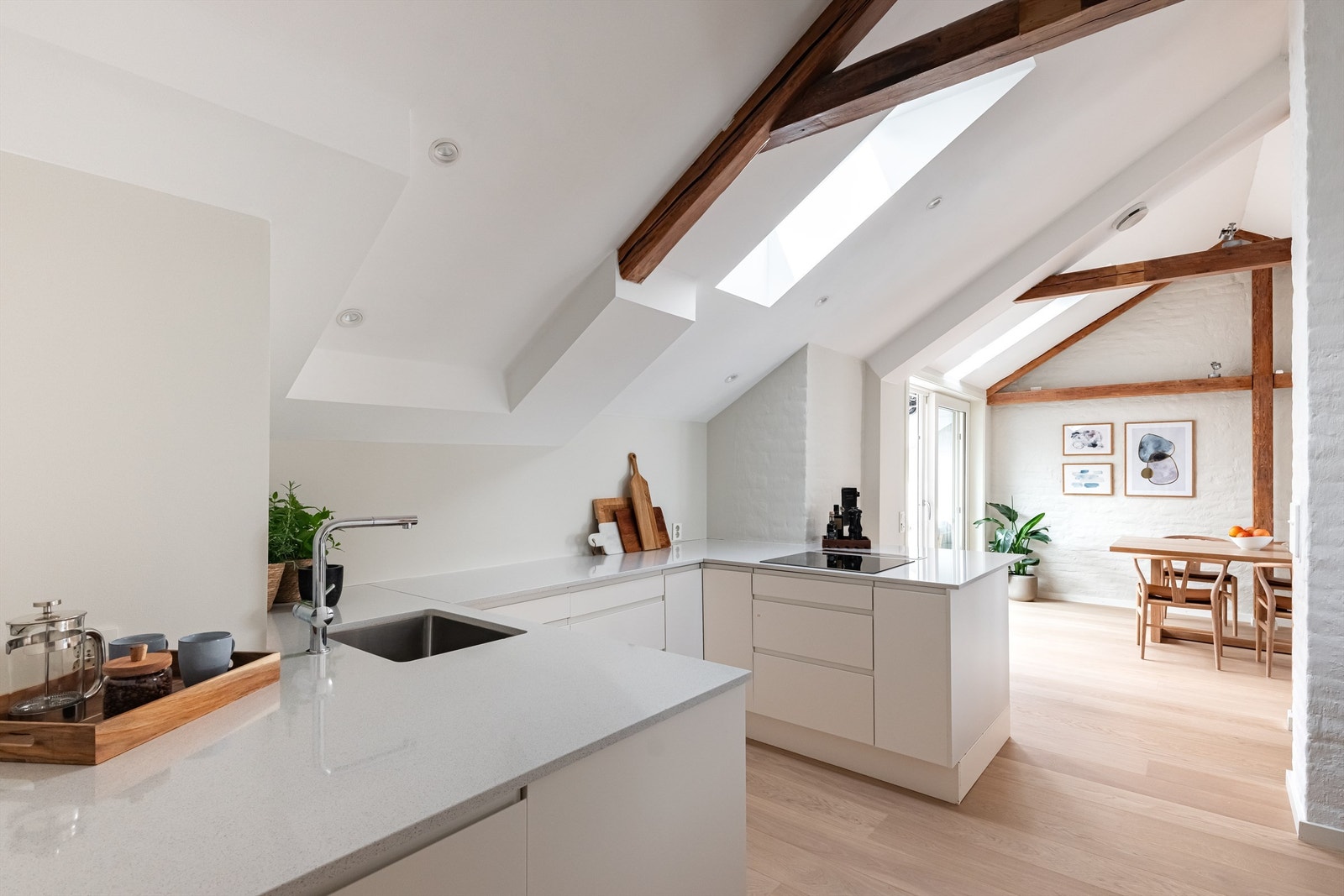 Kjøkkeninnredningen er av lyse, glatte fronter og en solid benkeplate i stein med nedfelt oppvaskkum. Galleribilde