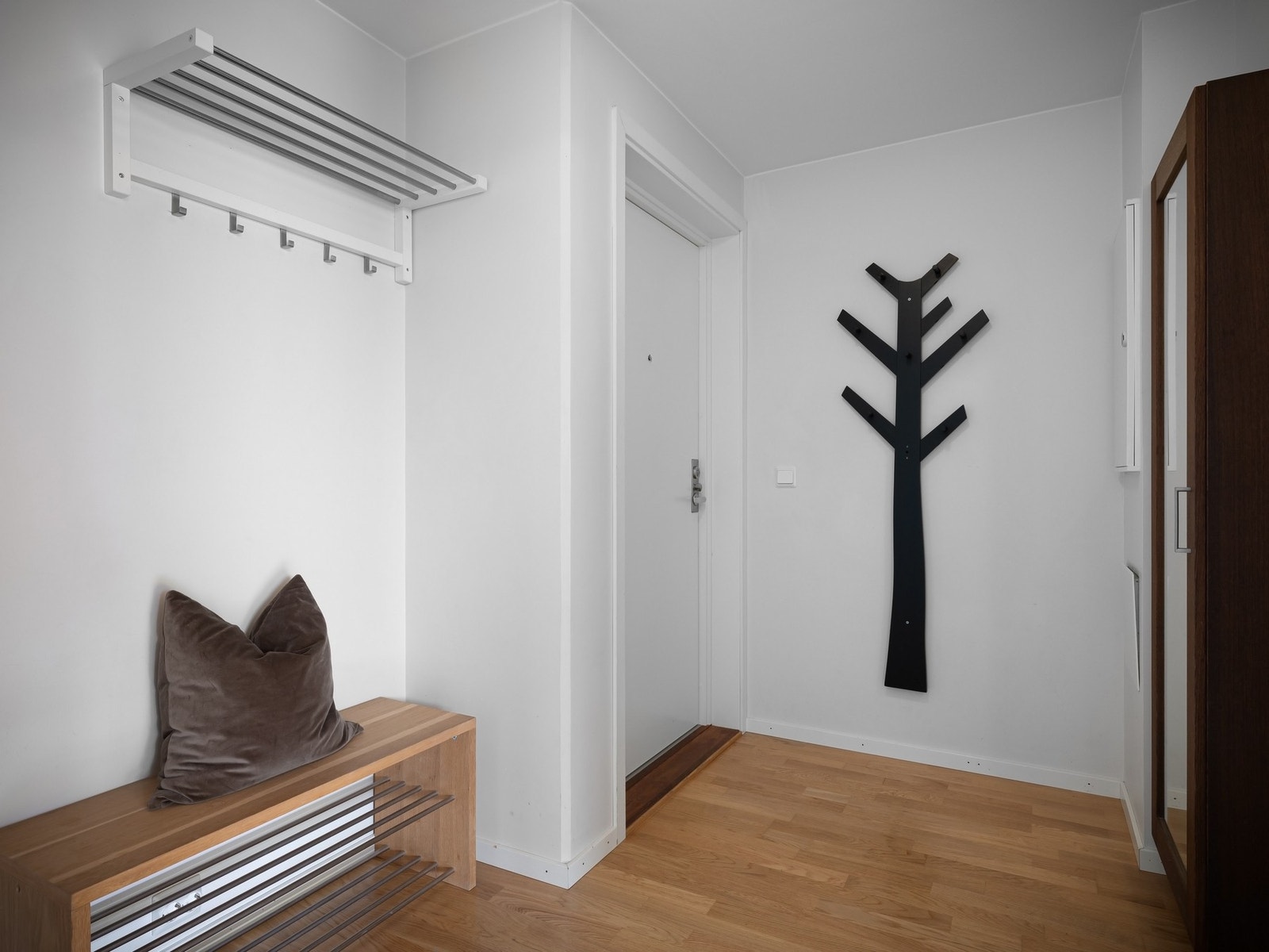 Lys og innbydende gang med plass til å henge fra seg tøy og sko Galleribilde