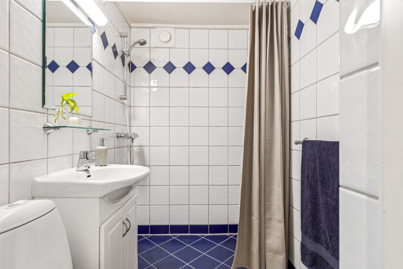 Leiligheten har et bad som er helfliset. Badet har blant annet gulvvarme, dusj og gulvstående wc. Galleribilde