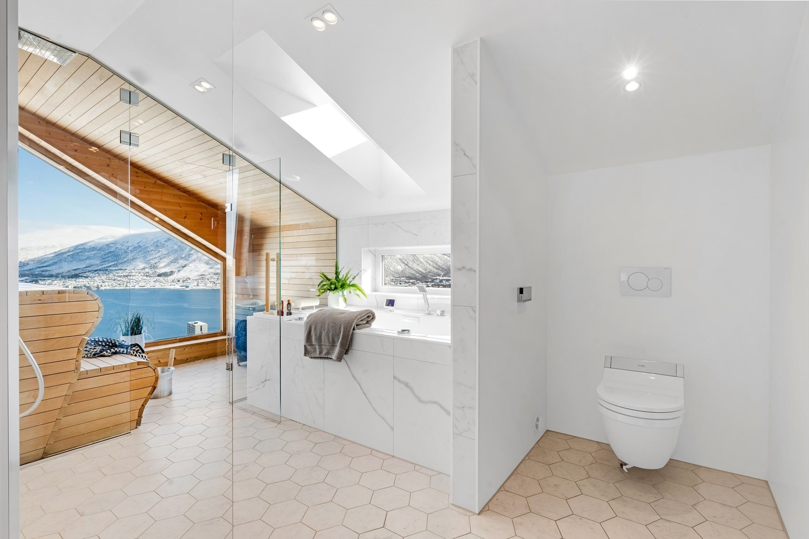 Gjennomtenkte løsninger og vakre, høykvalitets fliser viderefører boligens eksklusive særpreg. Vegghengt toalett med spylefunksjon. Galleribilde