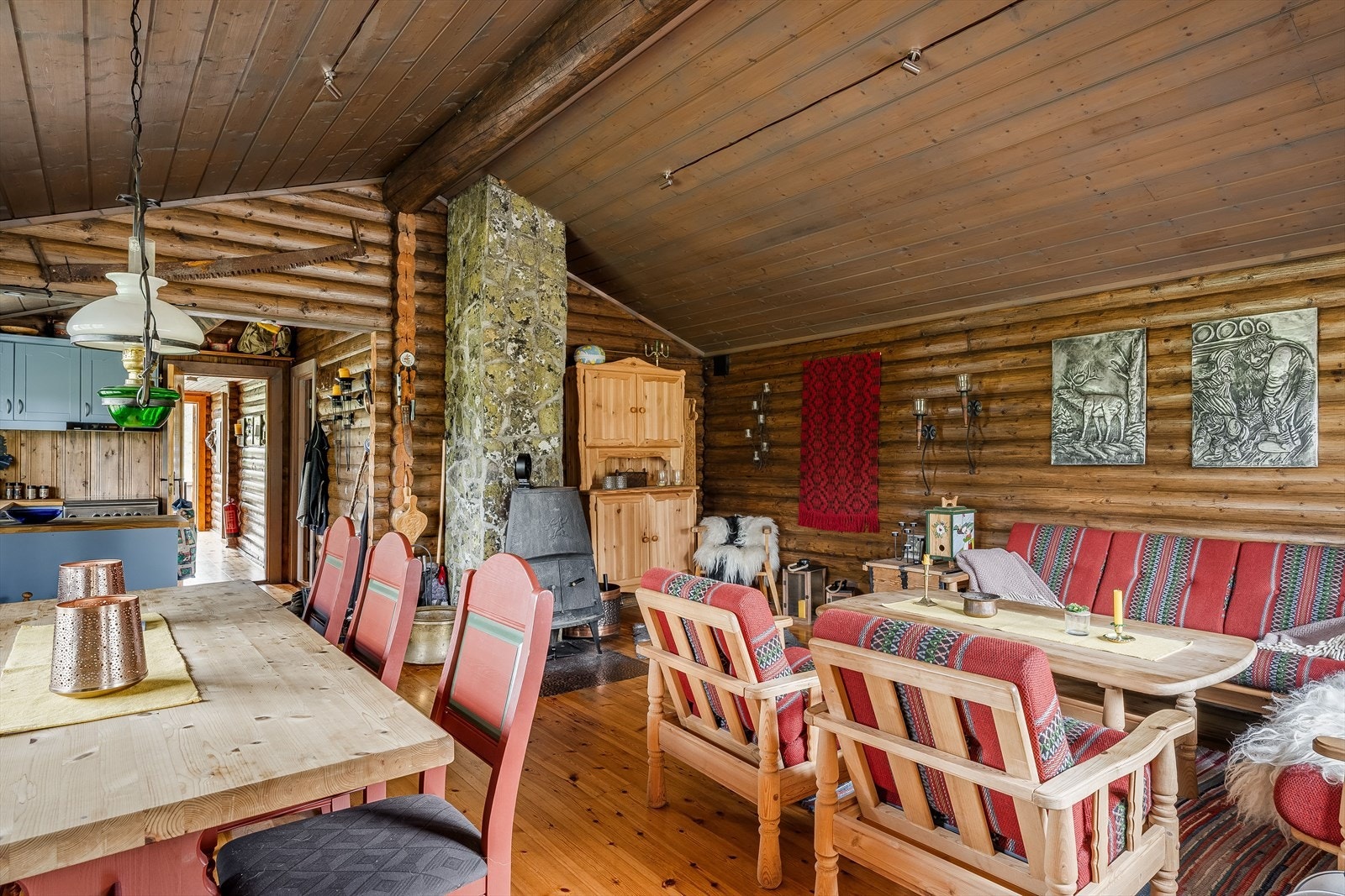 Hytta varmes opp ved hjelp av en solid vedovn. Den natursteinsbelagte pipa er et fint og stedegent midtpunkt i stuen. Galleribilde