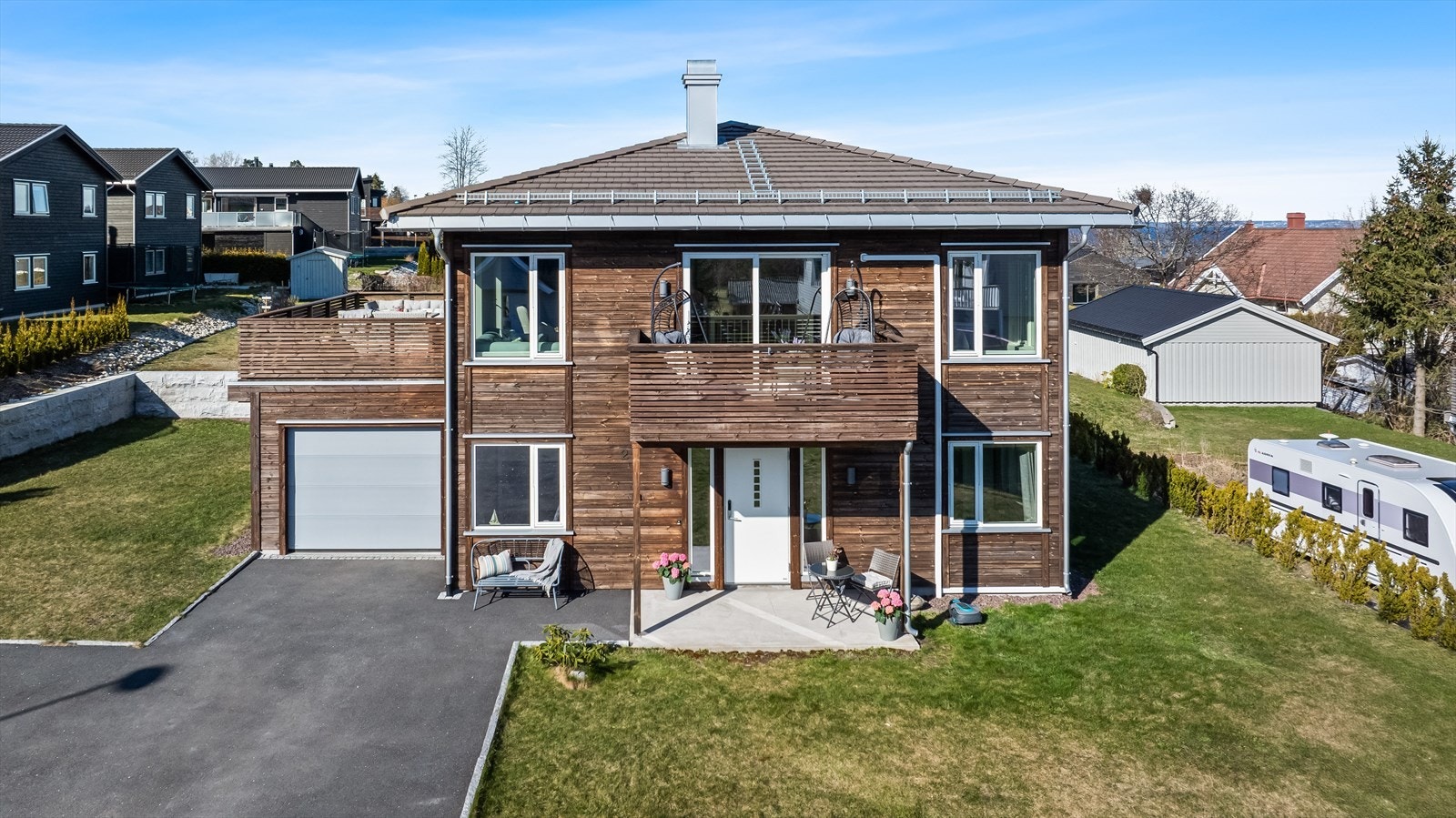 Uteområdet er like gjennomført som resten - en pent opparbeidet tomt med grønn plen og romslig gårdsplass, perfekt for både lek og sosiale sammenkomster. Galleribilde