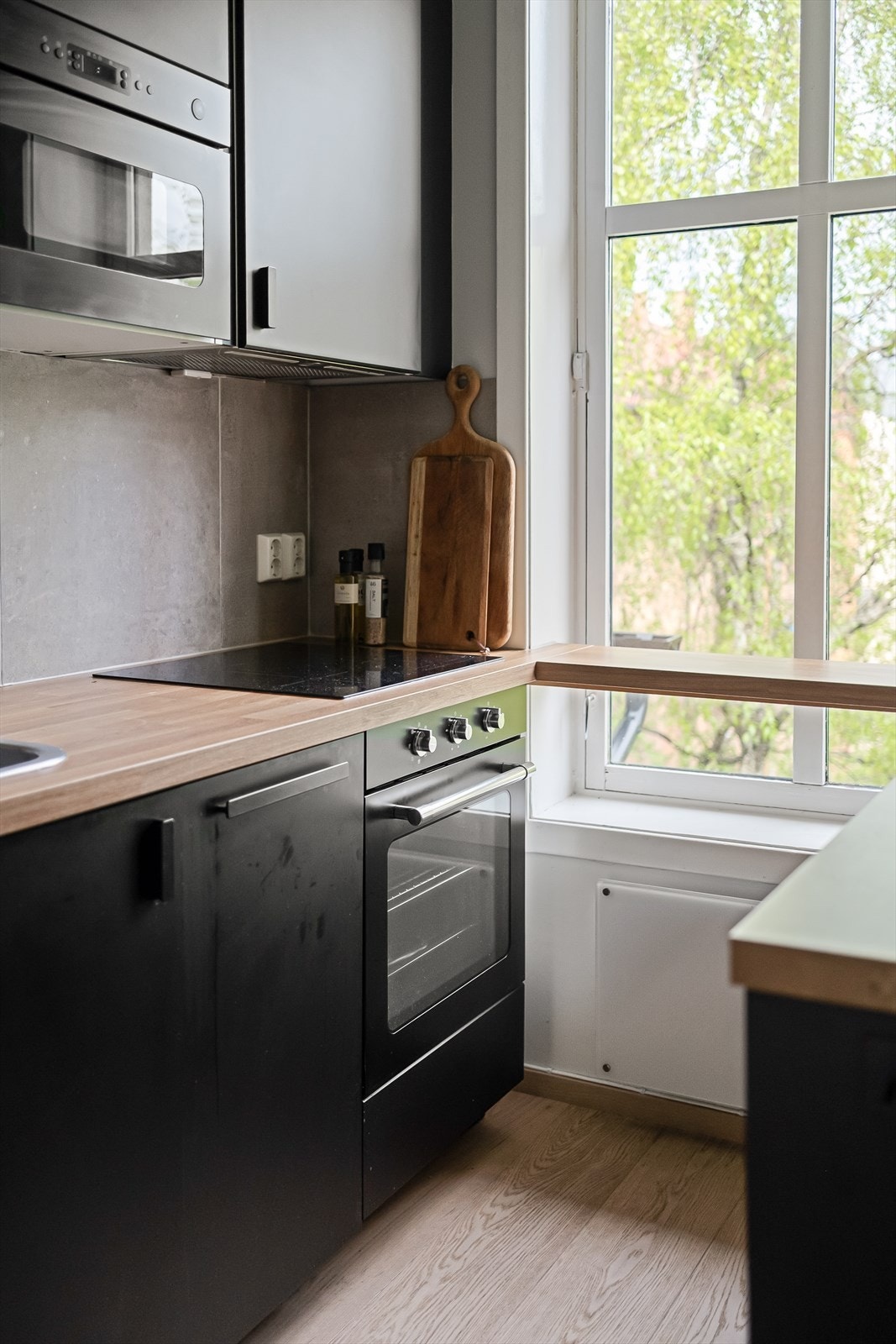 Moderne kjøkken med glatte fronter, laminat benkeplate med nedfelt vaskekum og fliser over benkeplaten. Galleribilde