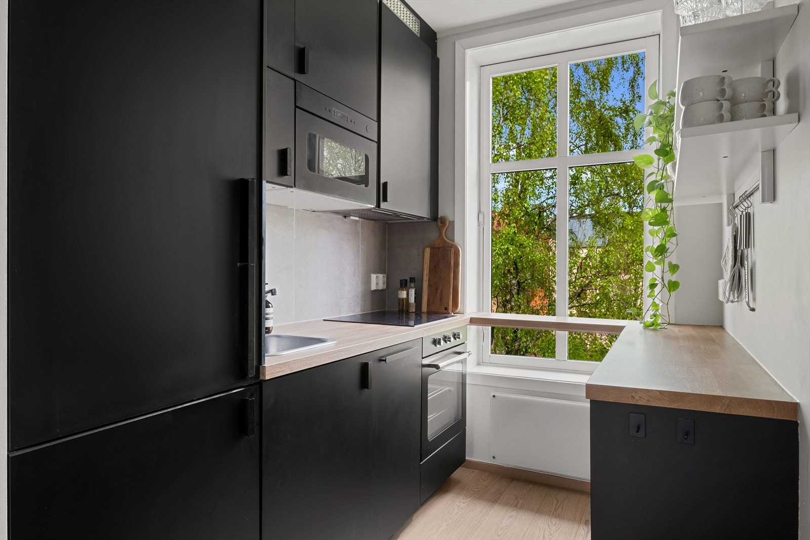 Stilfull kjøkkeninnredning i svart utførelse i tilknytning til entréen. Galleribilde