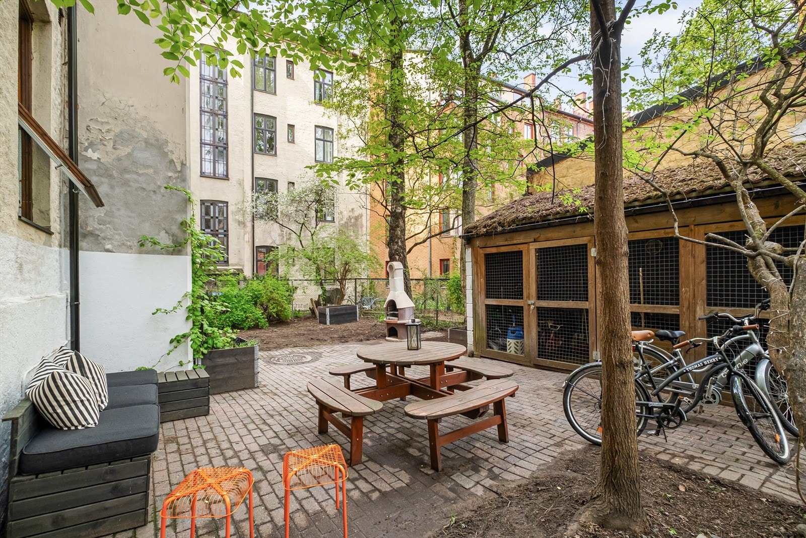 Bakgården byr på en hyggelig kombinasjon av grønne trær, sitteplasser og skjerming fra byens puls. Galleribilde