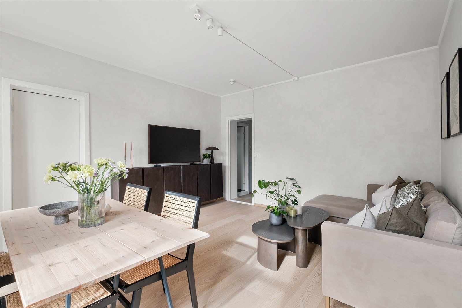 Hjertet i leiligheten er den romslige stuen med plass til både sofaseksjon med tilhørende møblement, TV-benk og spisebord. Galleribilde