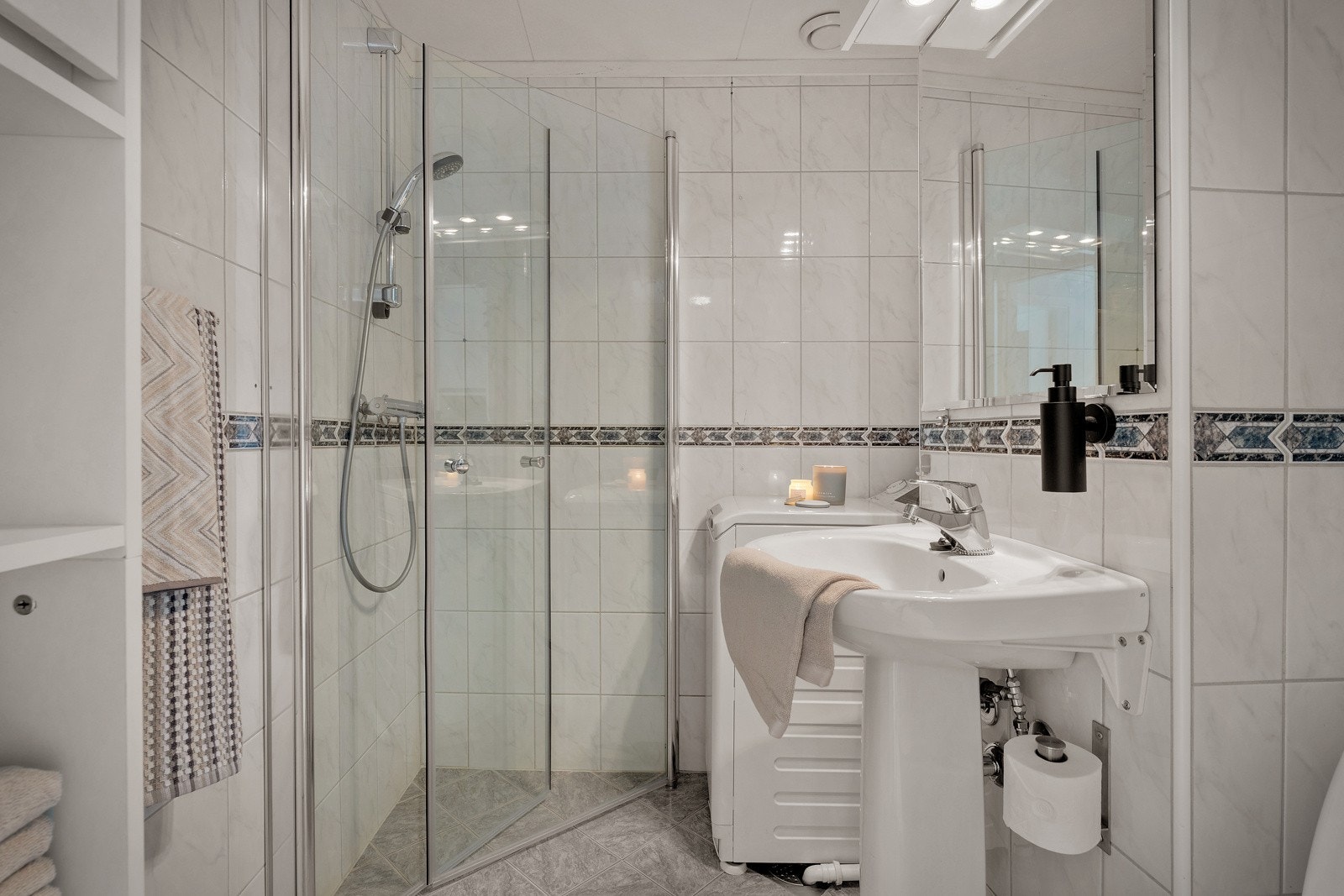 Fra gangen er det et praktisk og helfliset bad med dusjhjørne, servant og toalett. Galleribilde