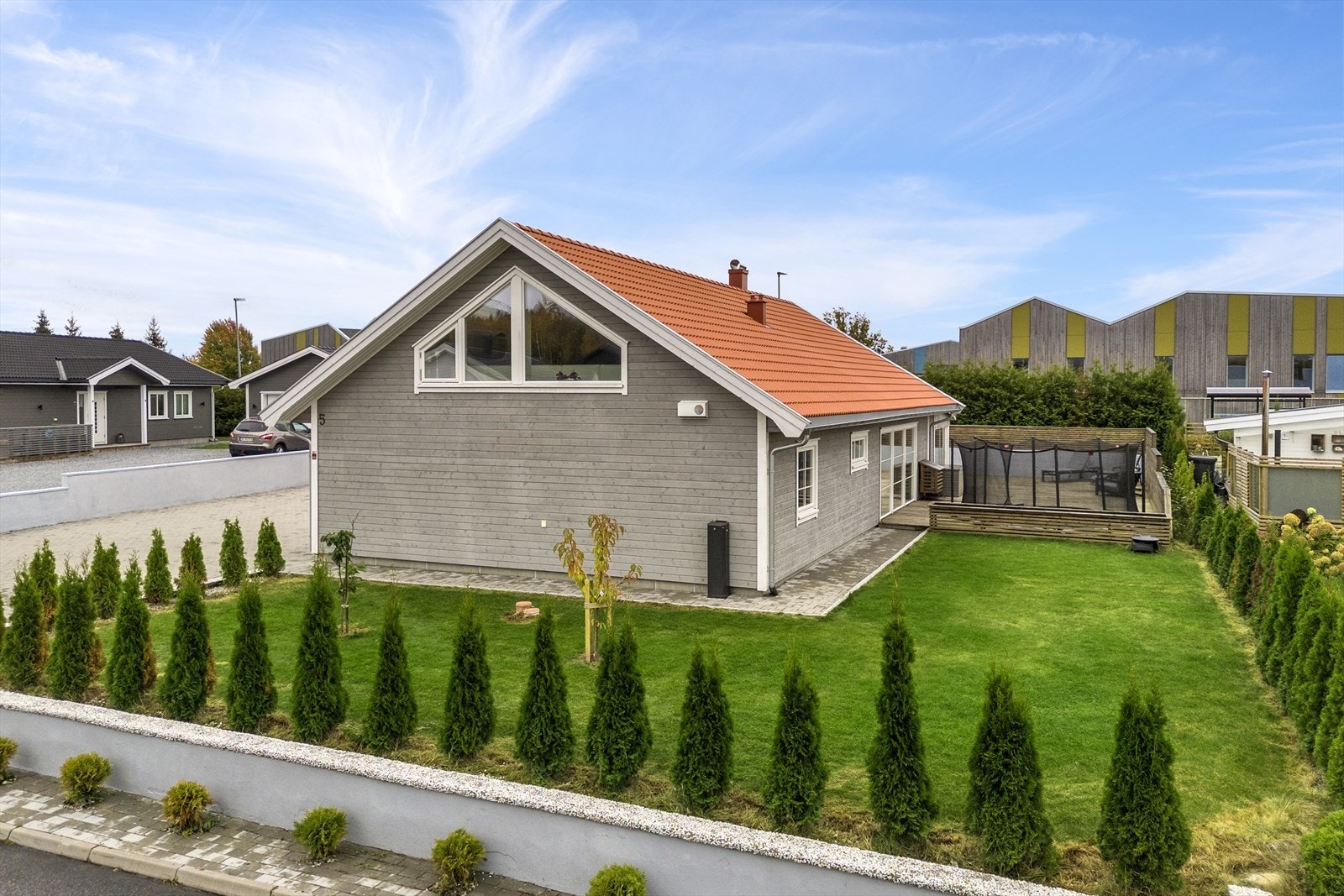 Eiendommen er opparbeidet helt ut til tomtegrensen med plantet hekk og støttemur Galleribilde