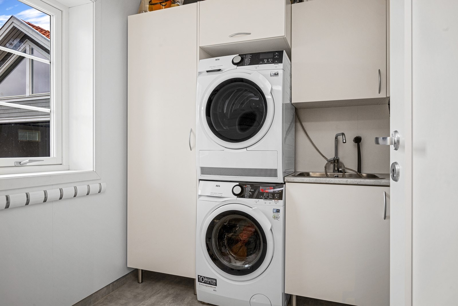 Praktisk vaskerom med opplegg for vaskemaskin og tørketrommel med god plassering i tilknytning entré Galleribilde