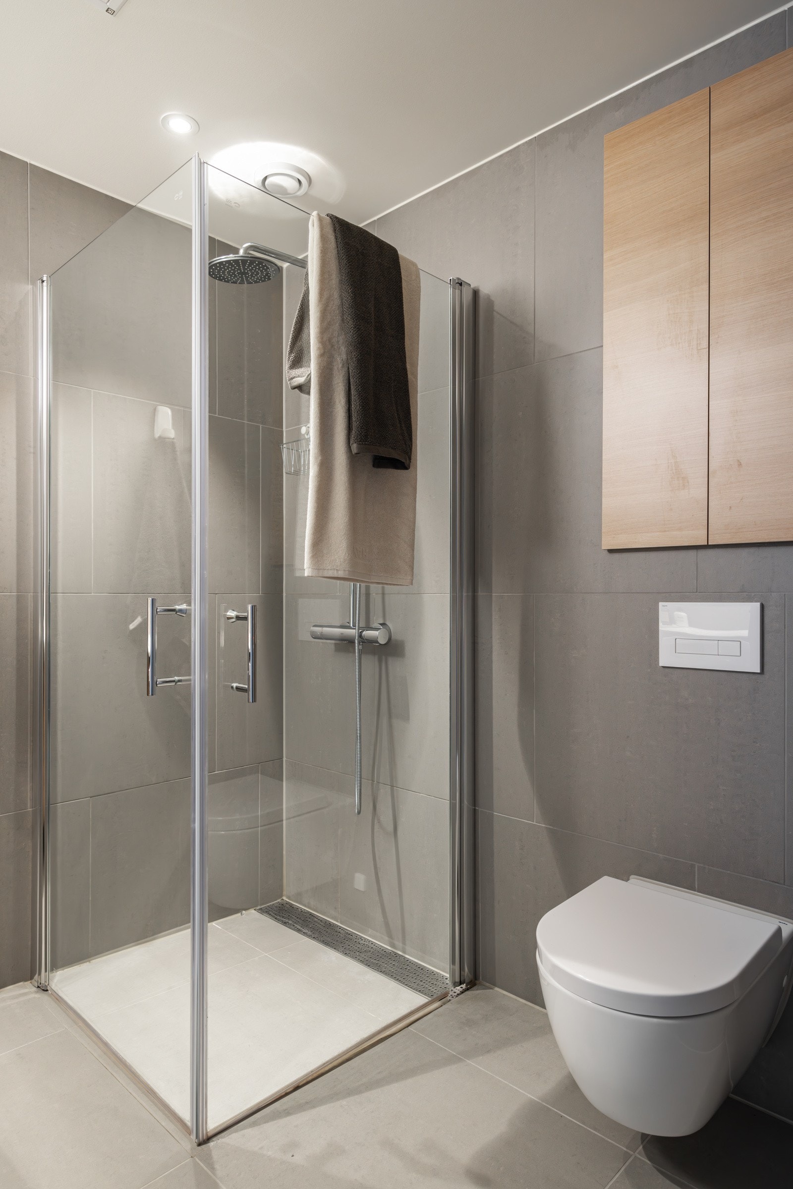 En romslig dusjplass bak glassdører. Galleribilde