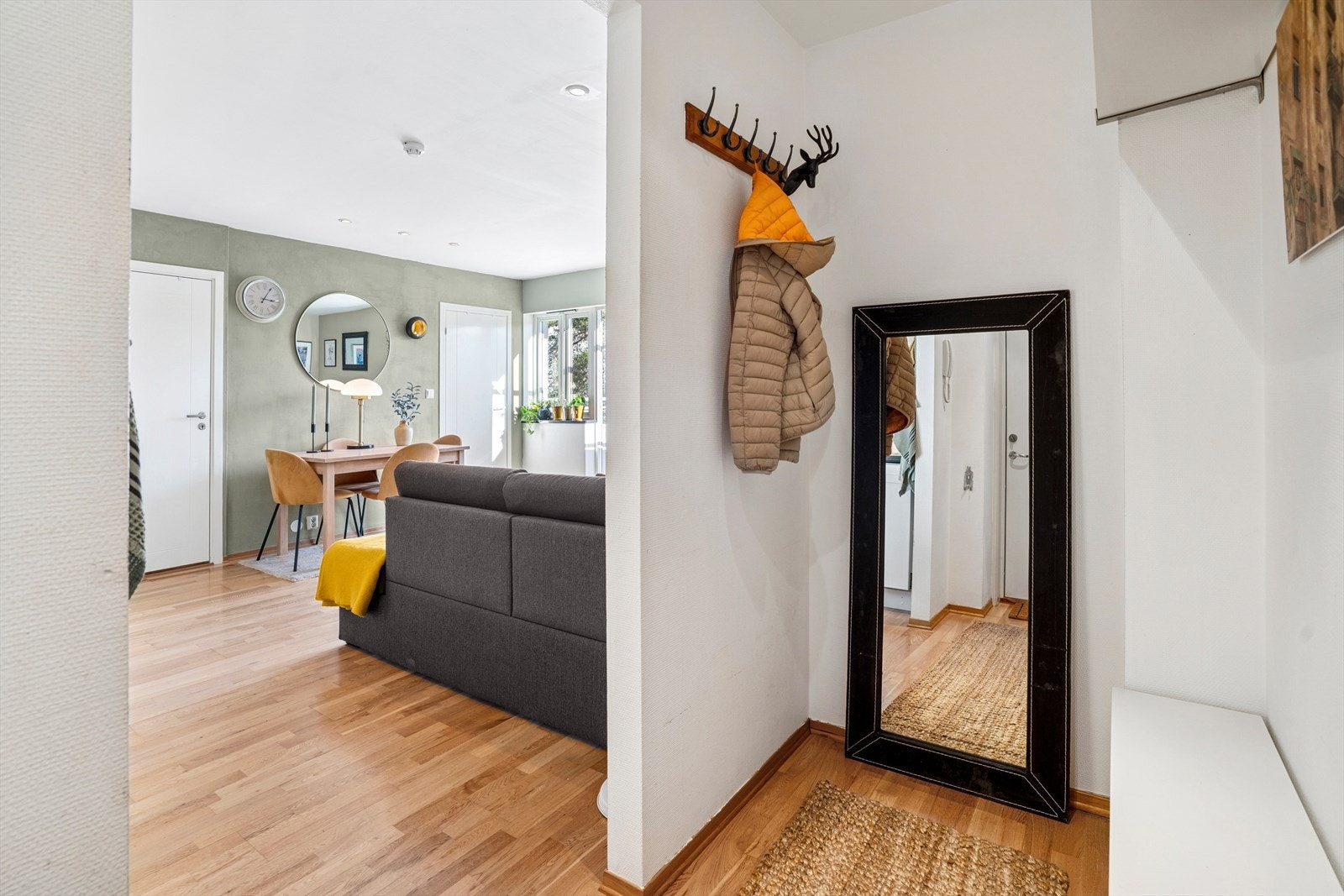 Inne i leiligheten møter man en lys og innbydende entré med plass til å henge fra seg yttertøy og sko. Galleribilde