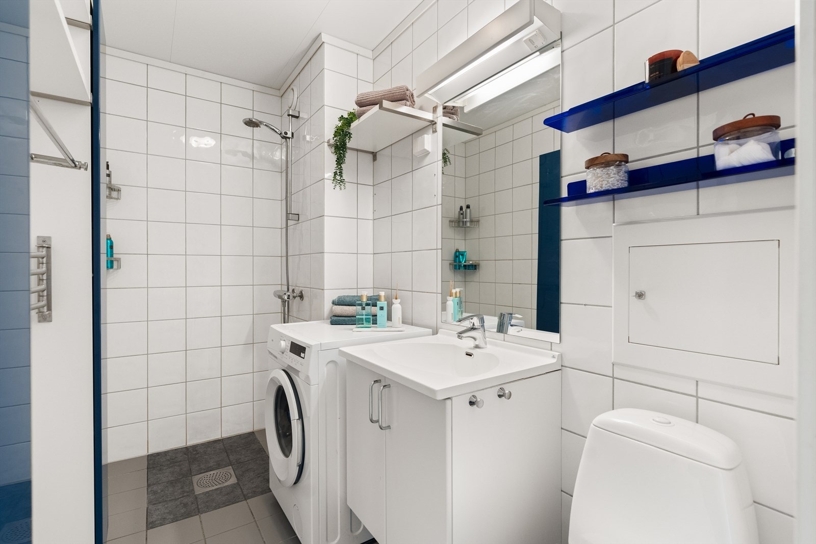 Pent og funksjonelt bad med fliser på både gulv og vegger, som gir et stilrent og tidløst uttrykk. Galleribilde