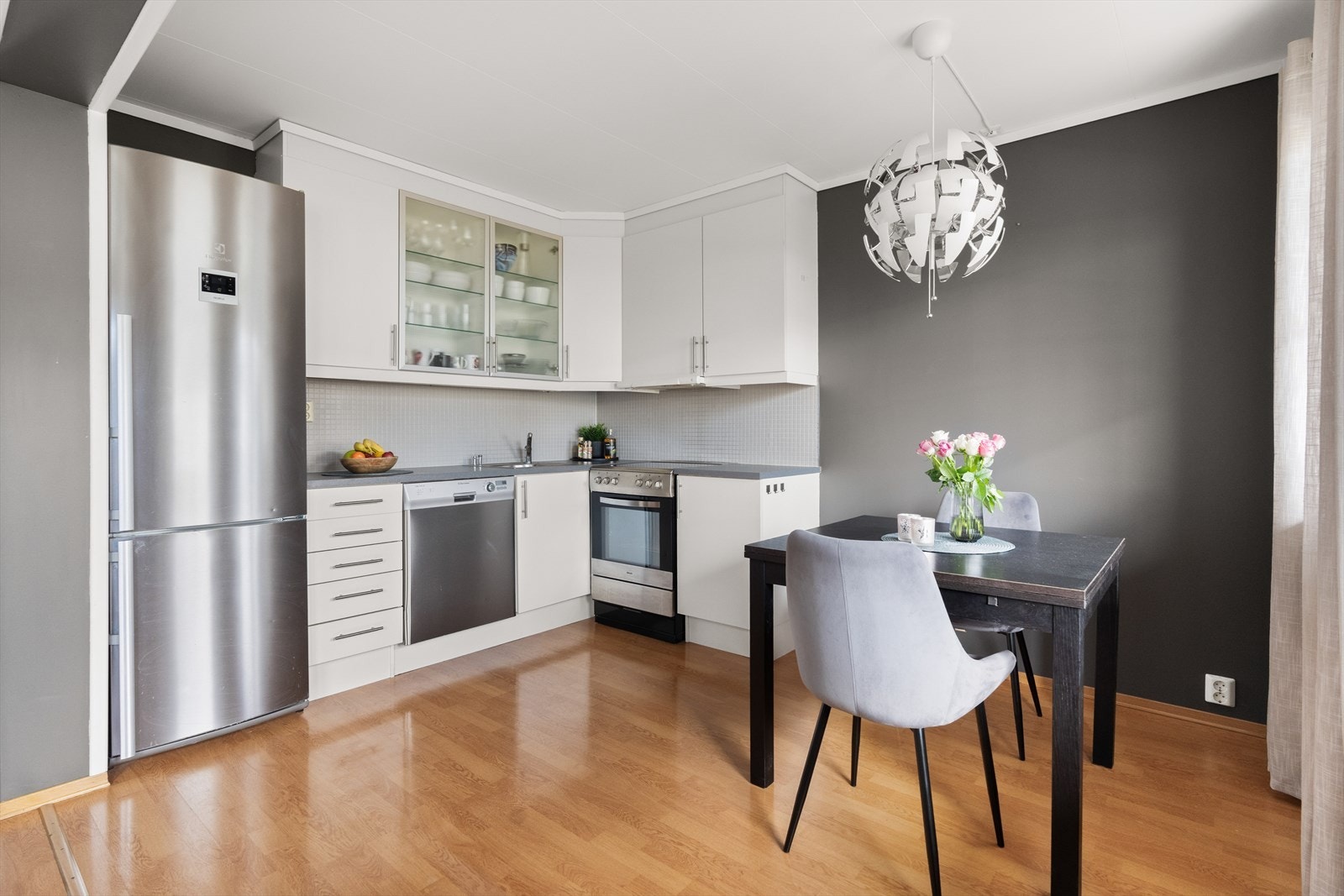 Kjøkkeninnredning med laminert benkeplate med nedfelt oppvaskkum med 1-greps blandebatteri. Fliser mellom over og underskap. Galleribilde