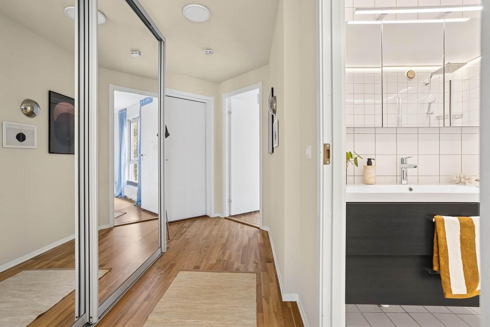 Praktisk entré med plass til oppbevaring av sko og yttertøy i skyvedørsgarderobe med speilfronter. Galleribilde