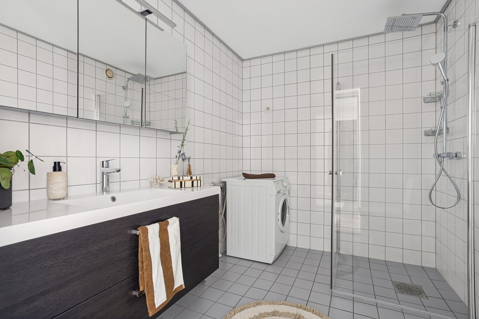 Baderomsinnredningen er bestående av dusjhjørne, toalett og servantskap med speilskap over. Galleribilde