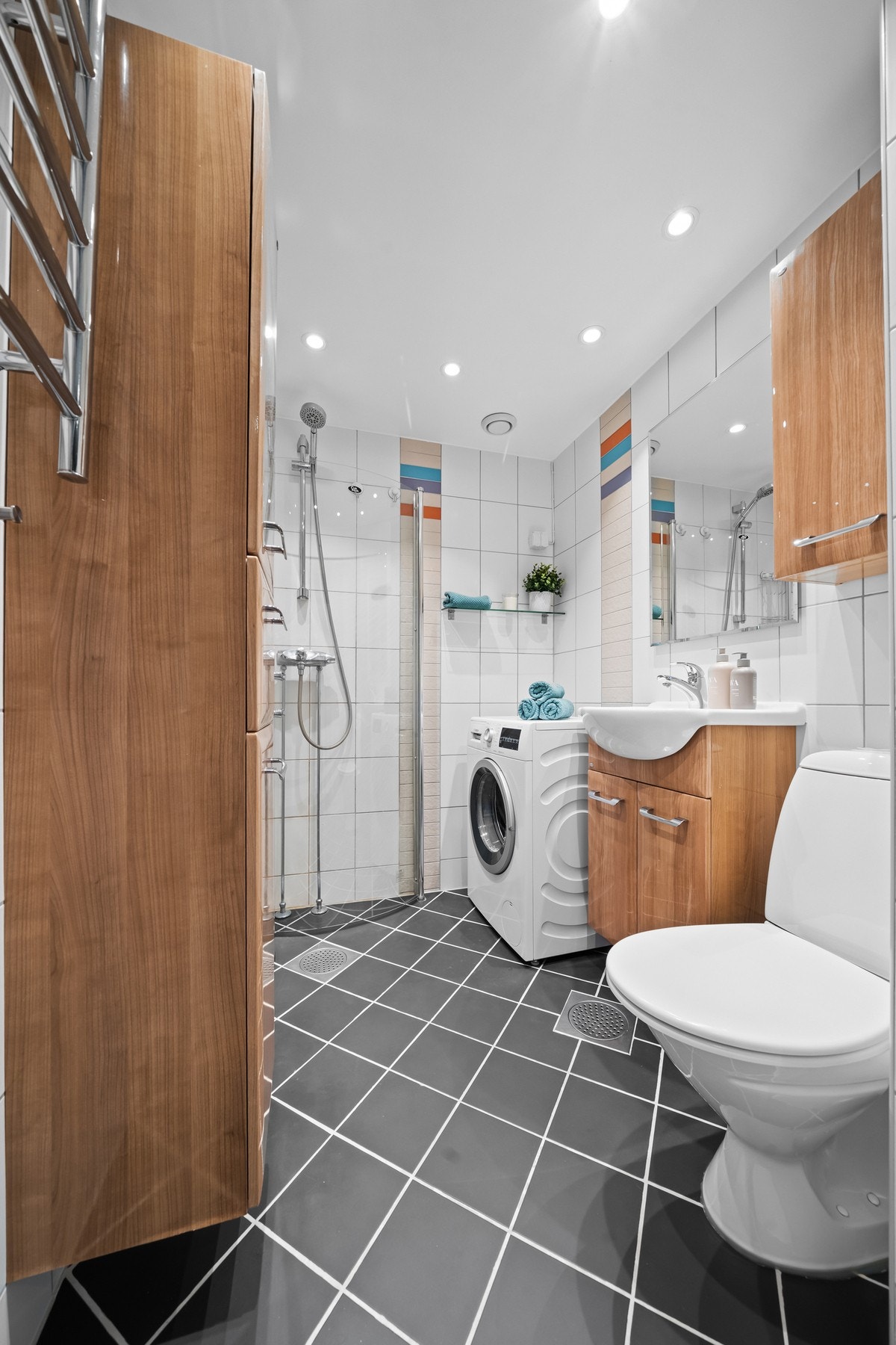 Her er det hvite fliser på veggene, downlights i himlingen og grå fliser på gulv med vannbåren gulvvarme. Galleribilde